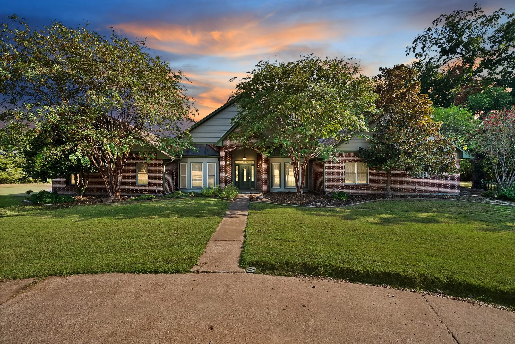 Expansive property featuring a circular driveway, mature trees, a swimming pool, and a single-story residence