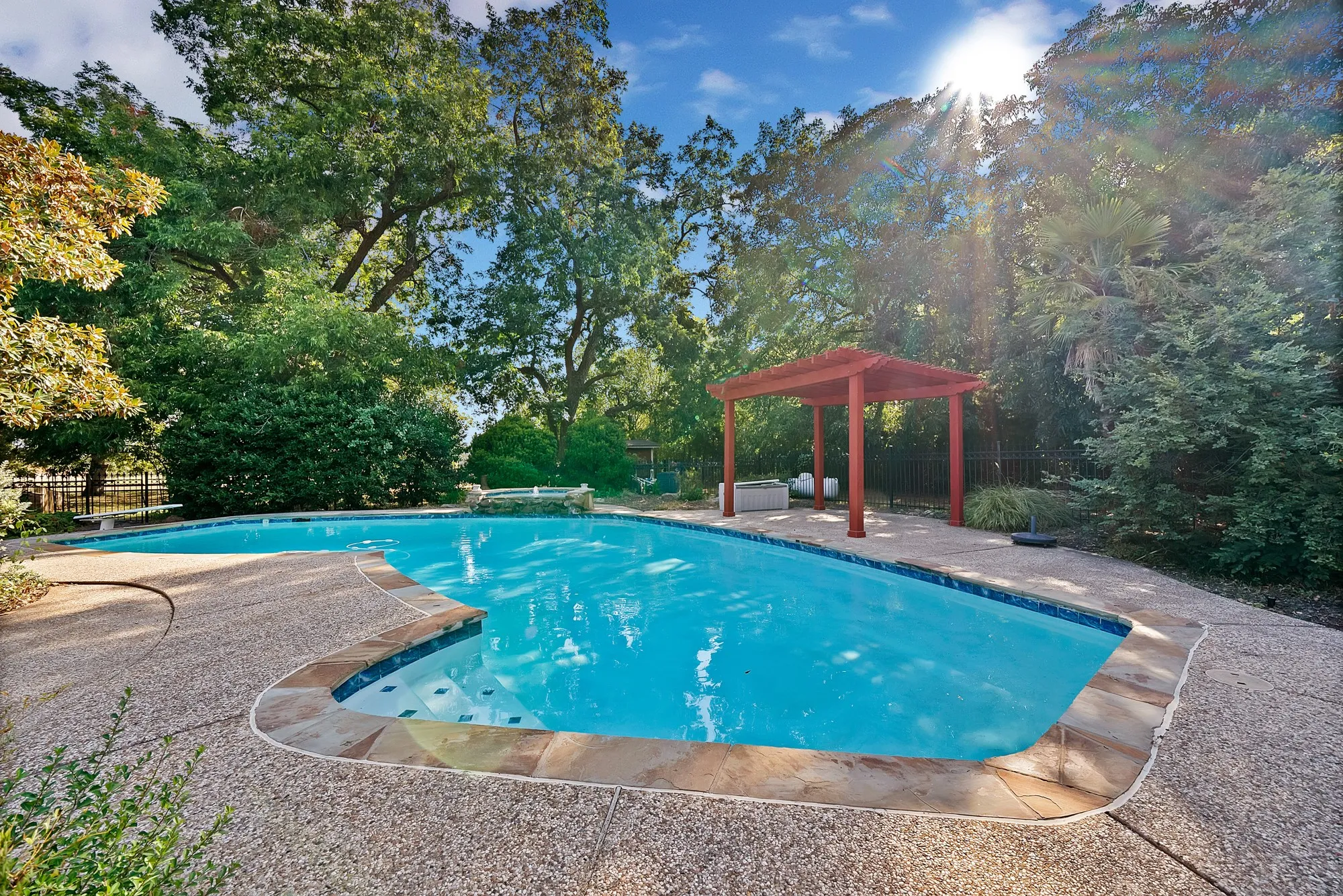 Swimming pool with a stone coping and a surrounding aggregate deck