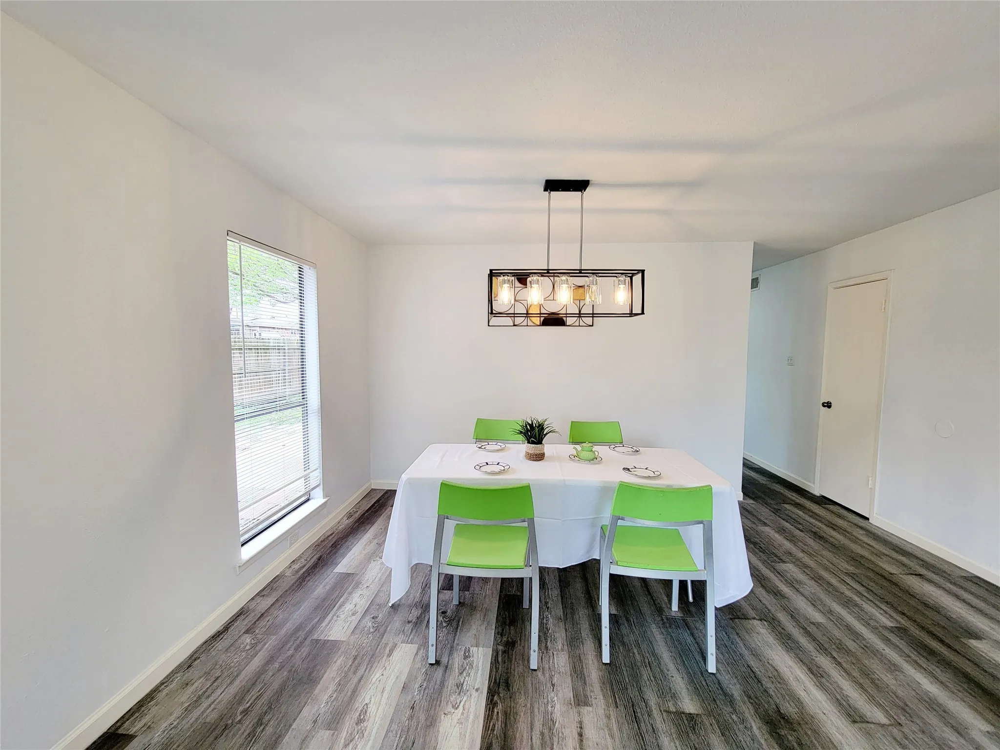 Dining area featuring baseboards, wood finished floors, and a notable chandelier