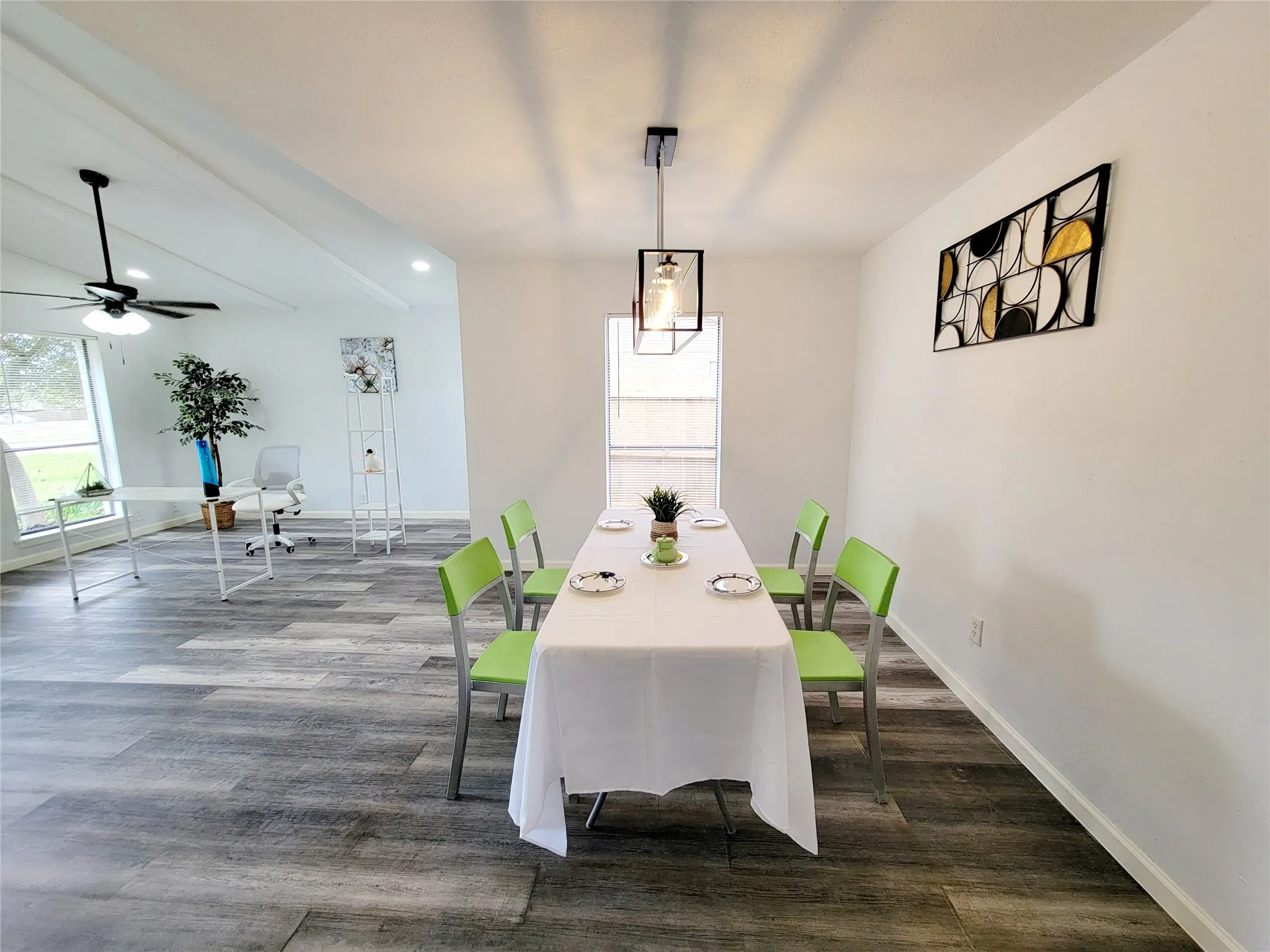 Dining space featuring dark wood-style floors, baseboards, beamed ceiling, and ceiling fan