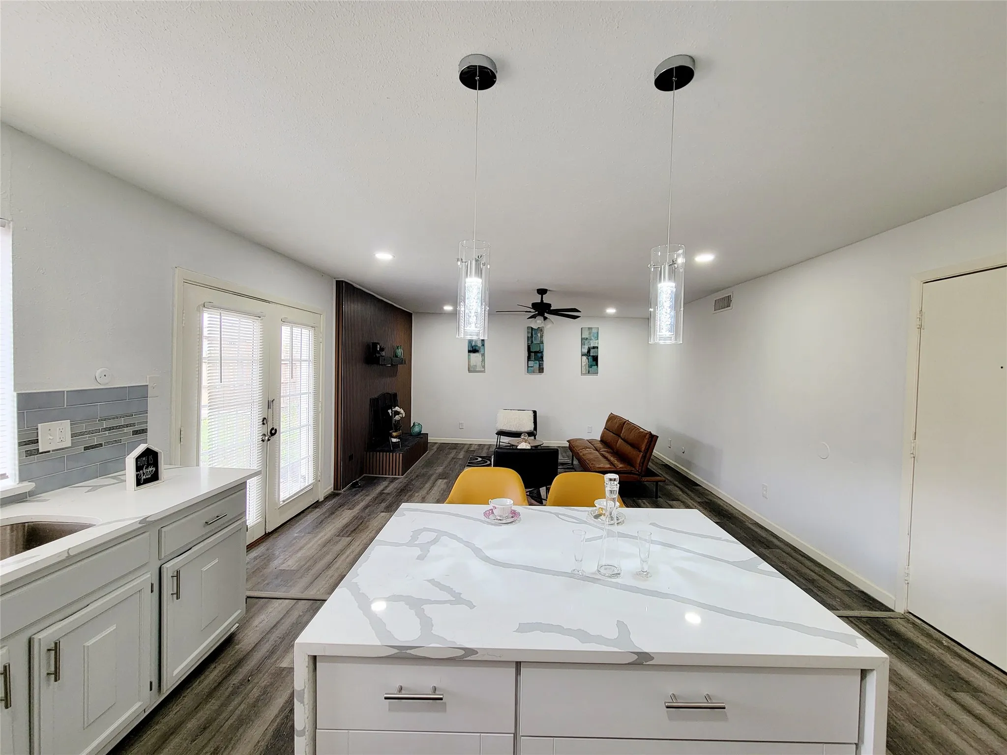 Kitchen with french doors, backsplash, a kitchen island, dark wood-style floors, and a ceiling fan