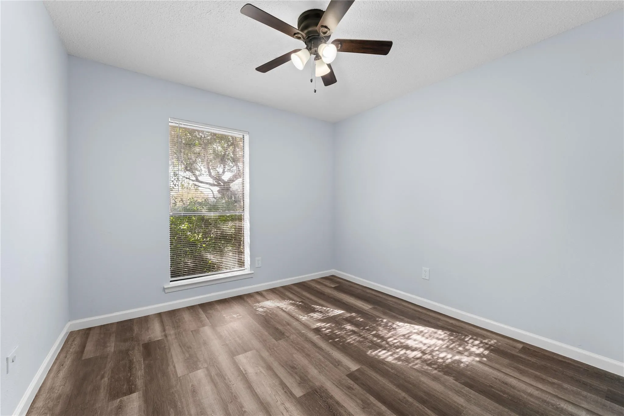 Empty room featuring baseboards, ceiling fan, and wood finished floors