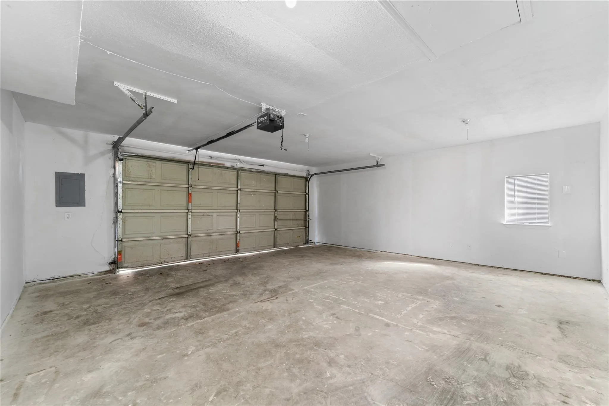 Garage featuring electric panel and a garage door opener