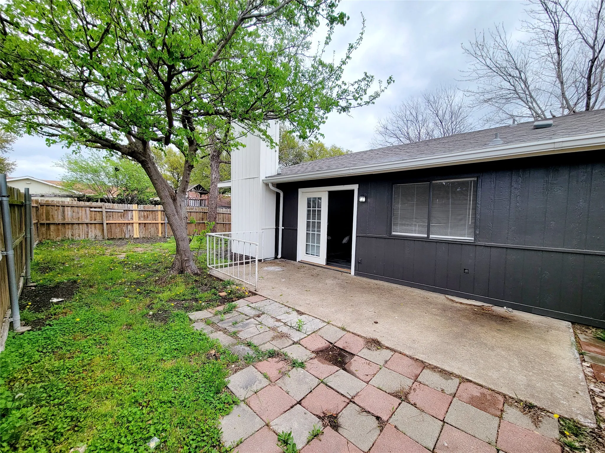 Back of property with a patio area, fence, and roof with shingles