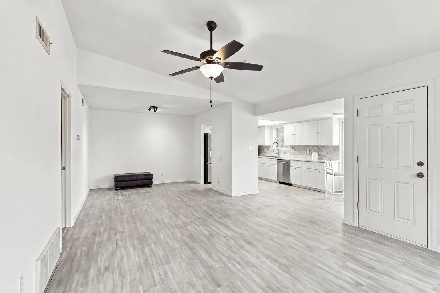 Bright, open living space with vaulted ceiling, updated flooring, and easy flow into the kitchen.