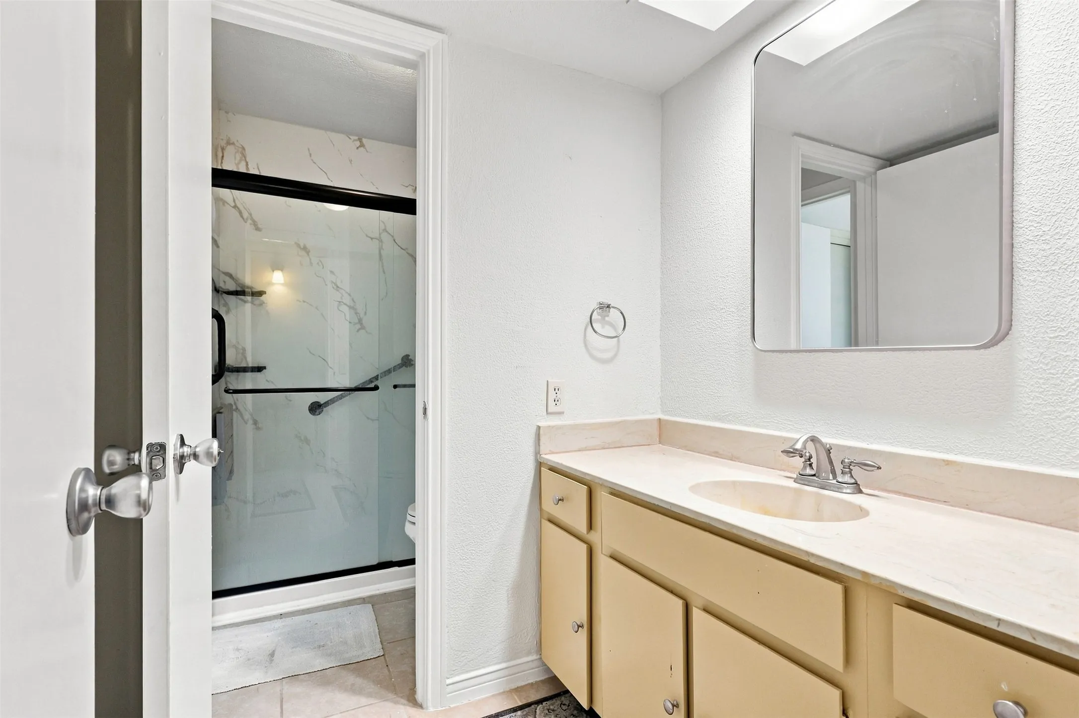 Updated full bath with modern walk-in shower and generous vanity space.