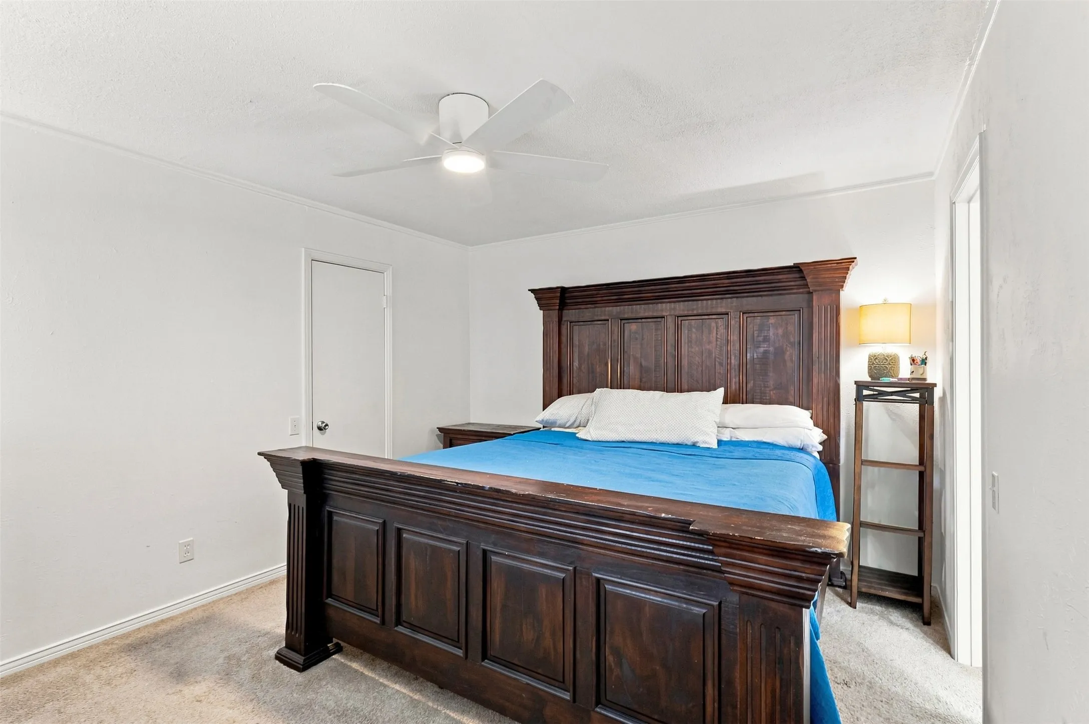 Spacious primary bedroom with ceiling fan, neutral finishes, and generous closet space.