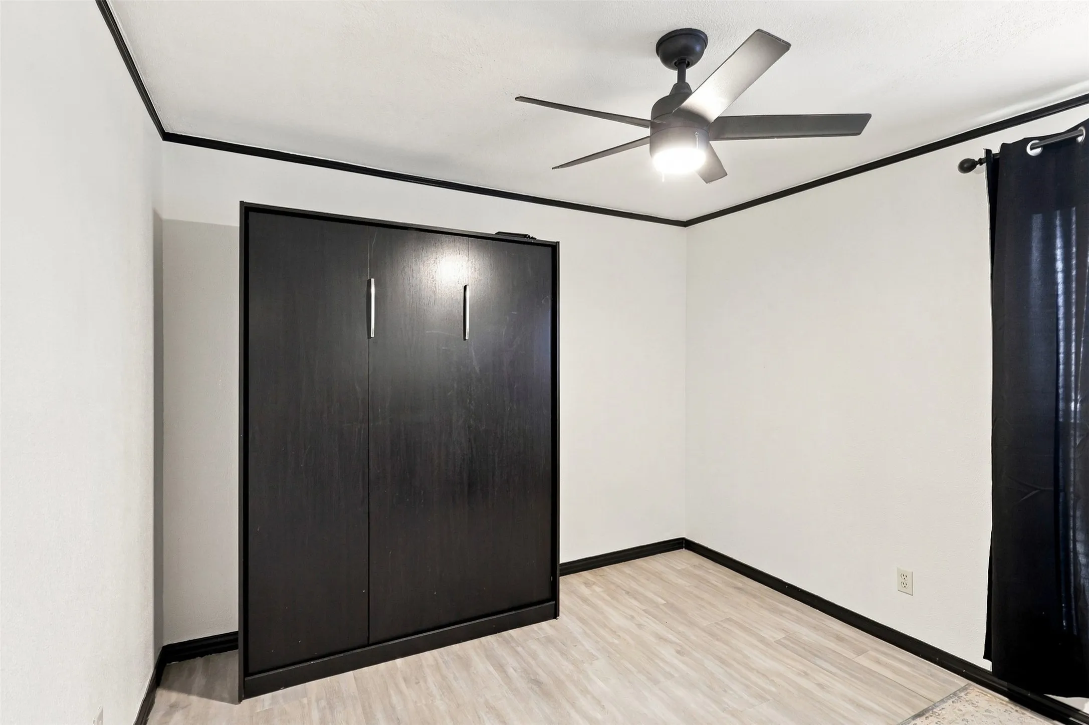 Versatile secondary bedroom with a space-saving Murphy bed, ideal for guests or a home office.