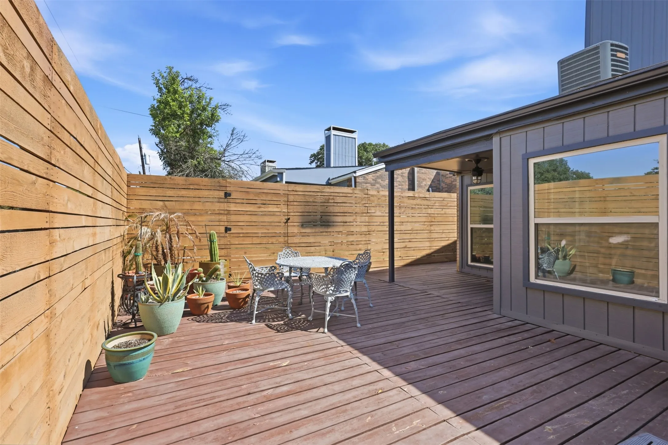 Spacious private deck surrounded by wood fencing for outdoor dining, grilling, or relaxing.
