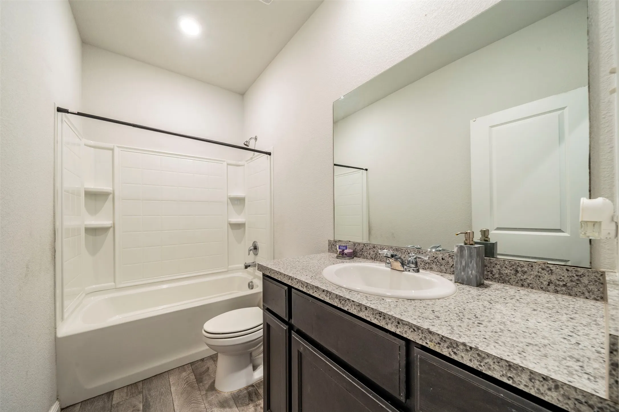 Vanity with a speckled countertop and integrated basin