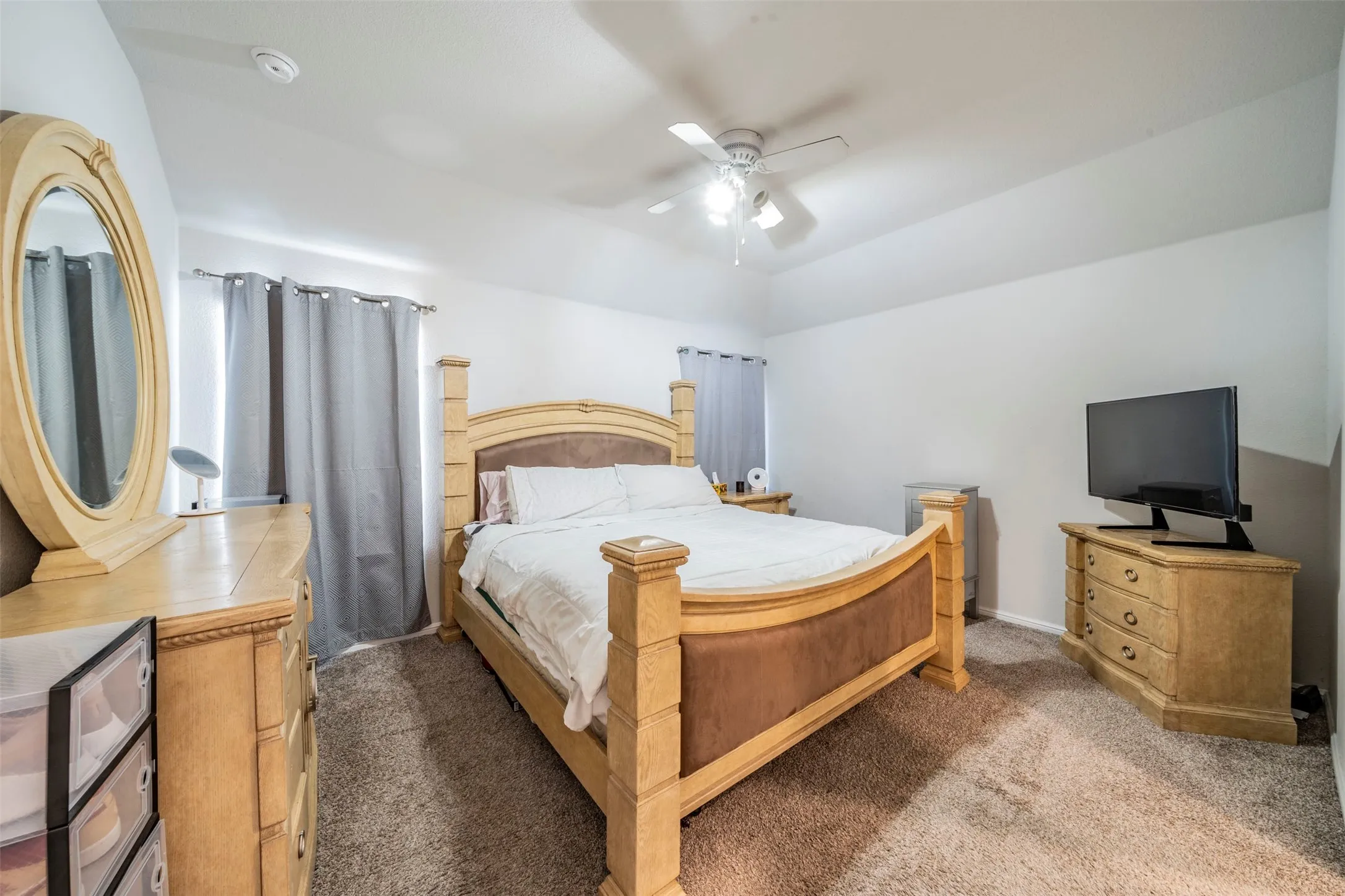 Carpeted flooring, vaulted ceiling, and ceiling fan with light fixture