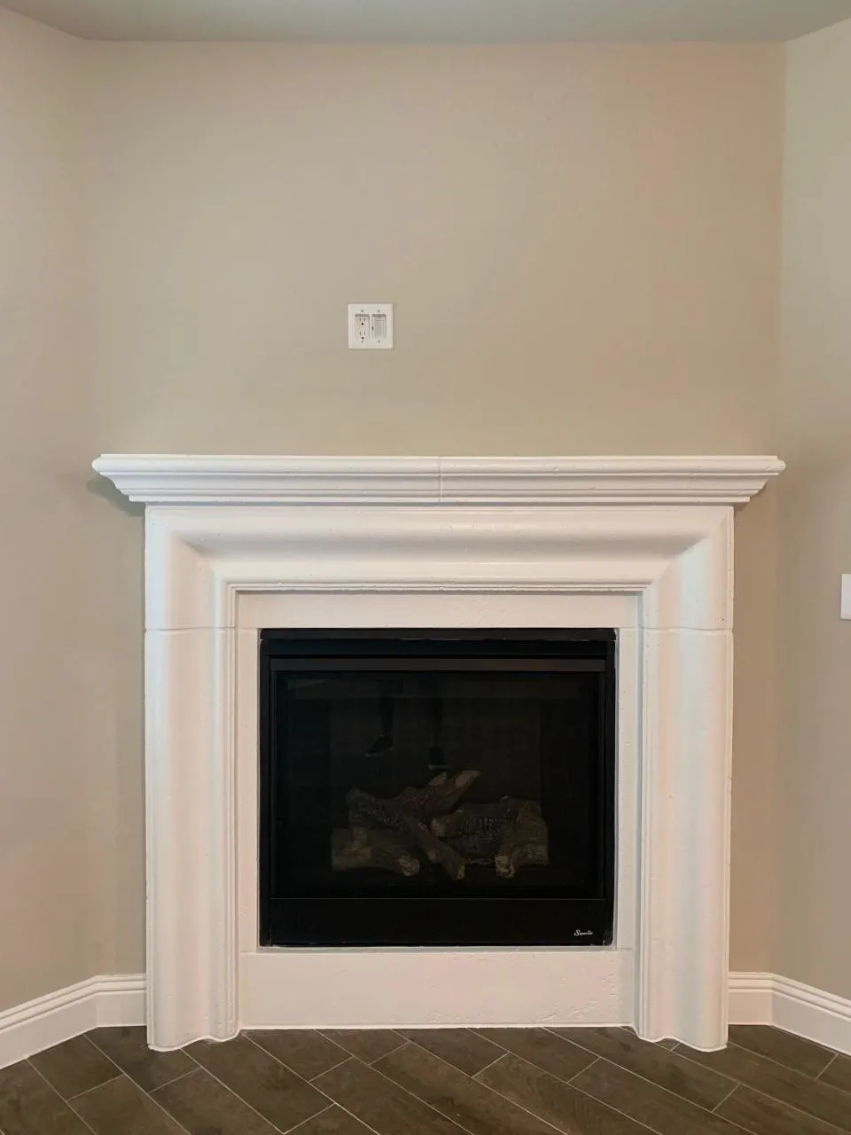 Built-in fireplace with a white mantel and surround, featuring a black firebox and a glass door