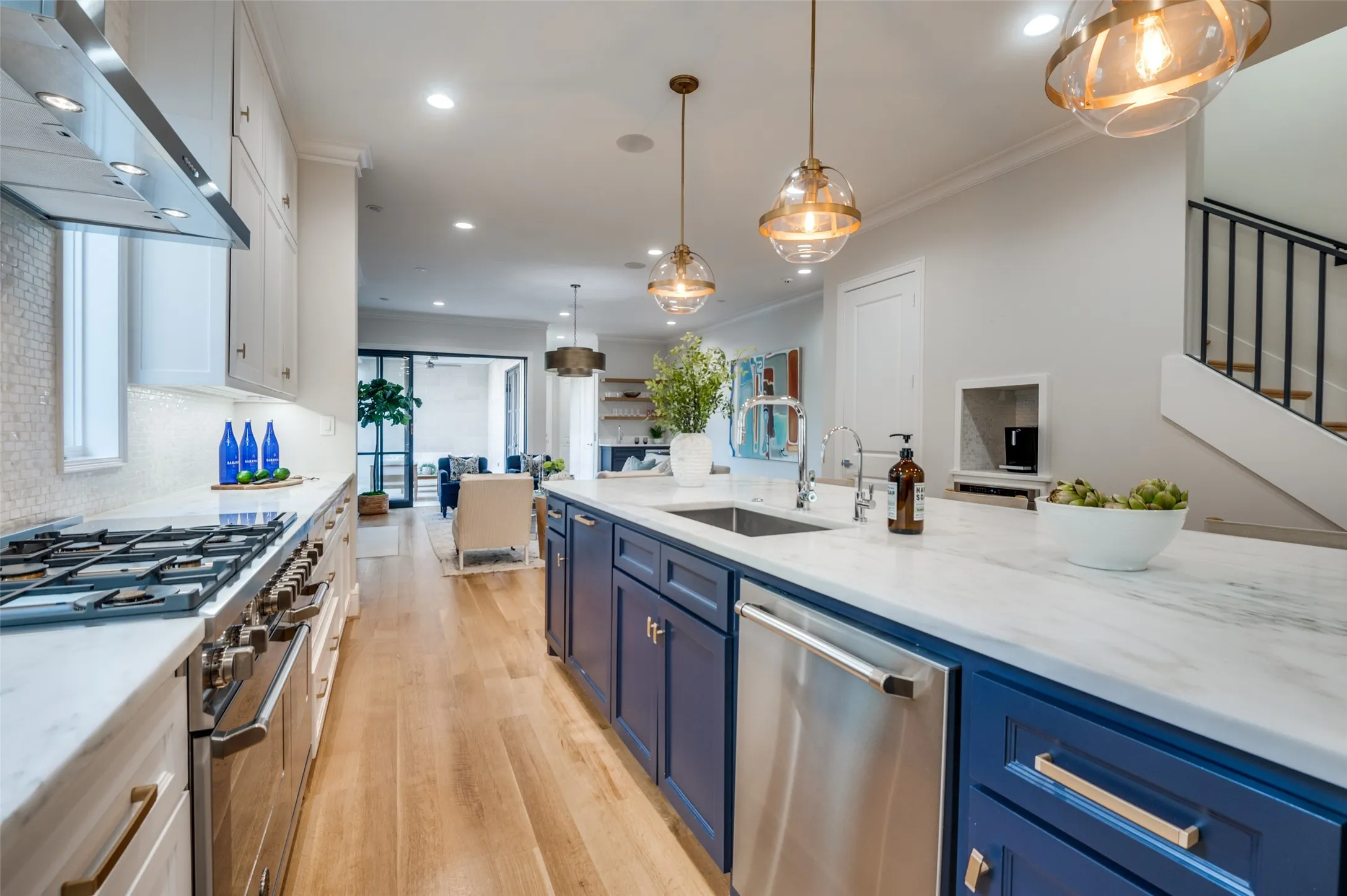Gourmet kitchen with stainless steel range, white quartz countertops, full-height white tile backsplash, and wood-finish flooring