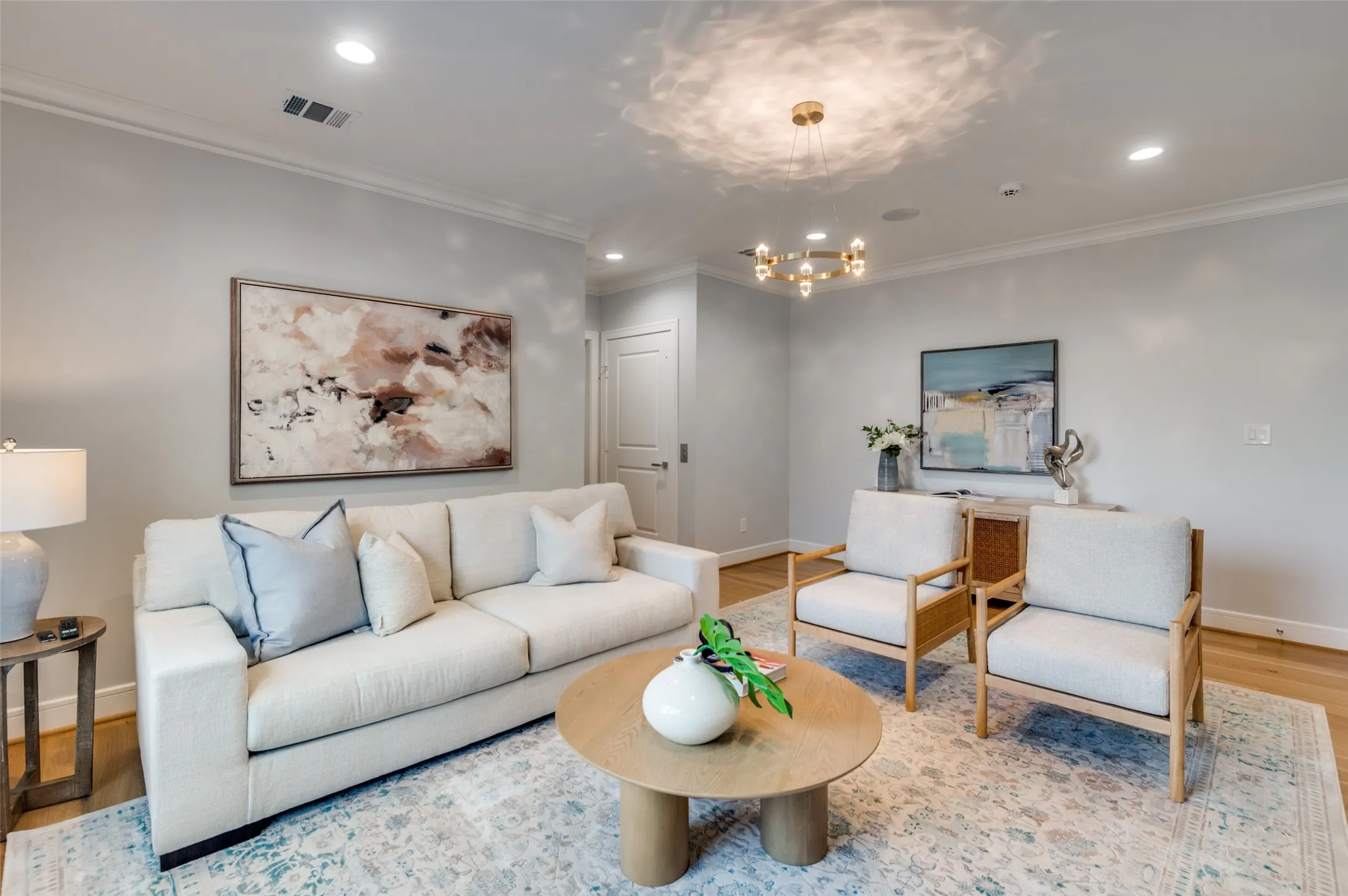 Recessed lighting, crown molding, wood-finish flooring, and a modern chandelier