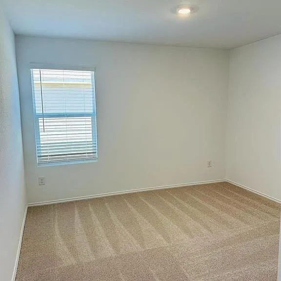 Neutral wall paint, beige carpet, recessed ceiling lighting, and a window with blinds
