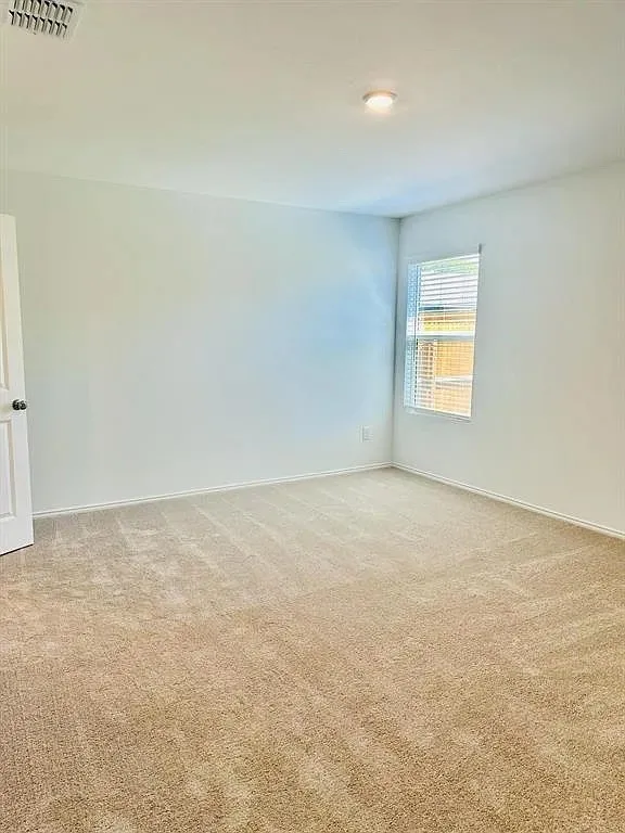 Recessed ceiling light, neutral-toned carpet, white painted walls, and window with blinds