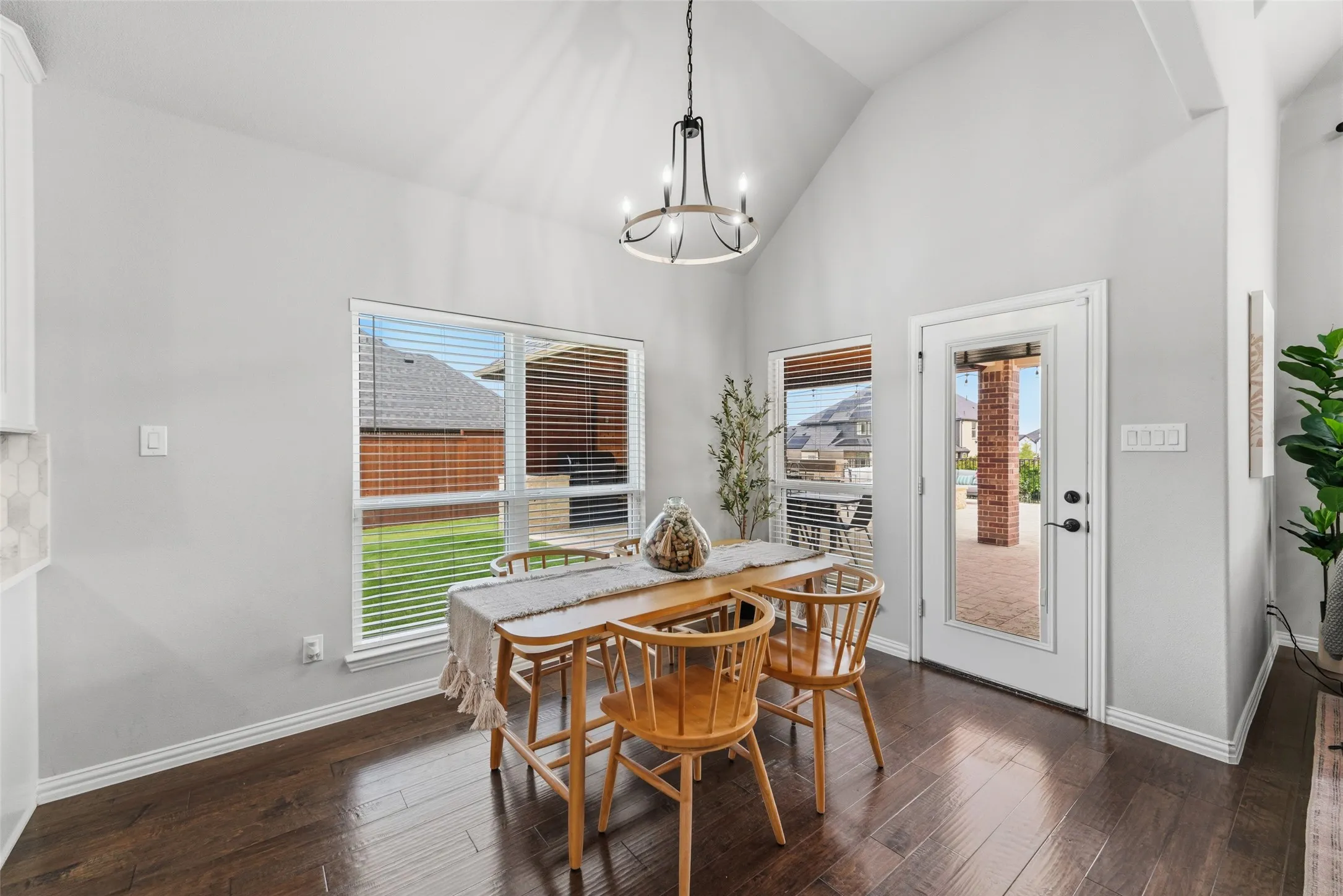 Vaulted ceiling with an overhead light fixture, wood-finish flooring, and a glass-paned exterior door