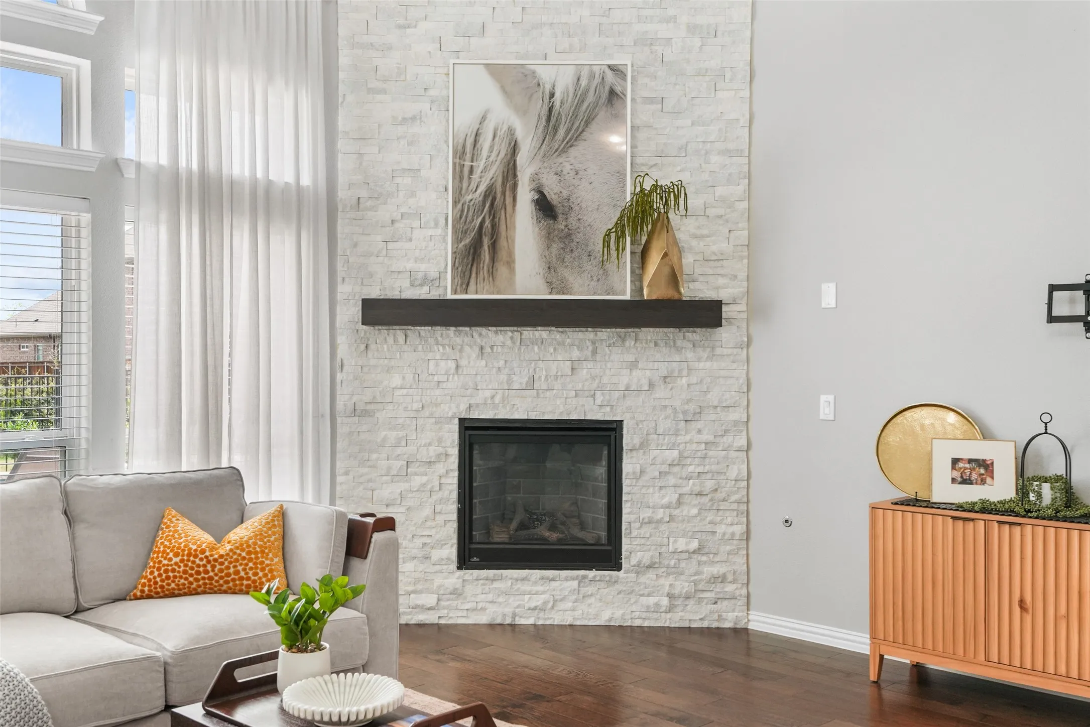Stone-clad fireplace with a dark wood-finish mantel and a black firebox