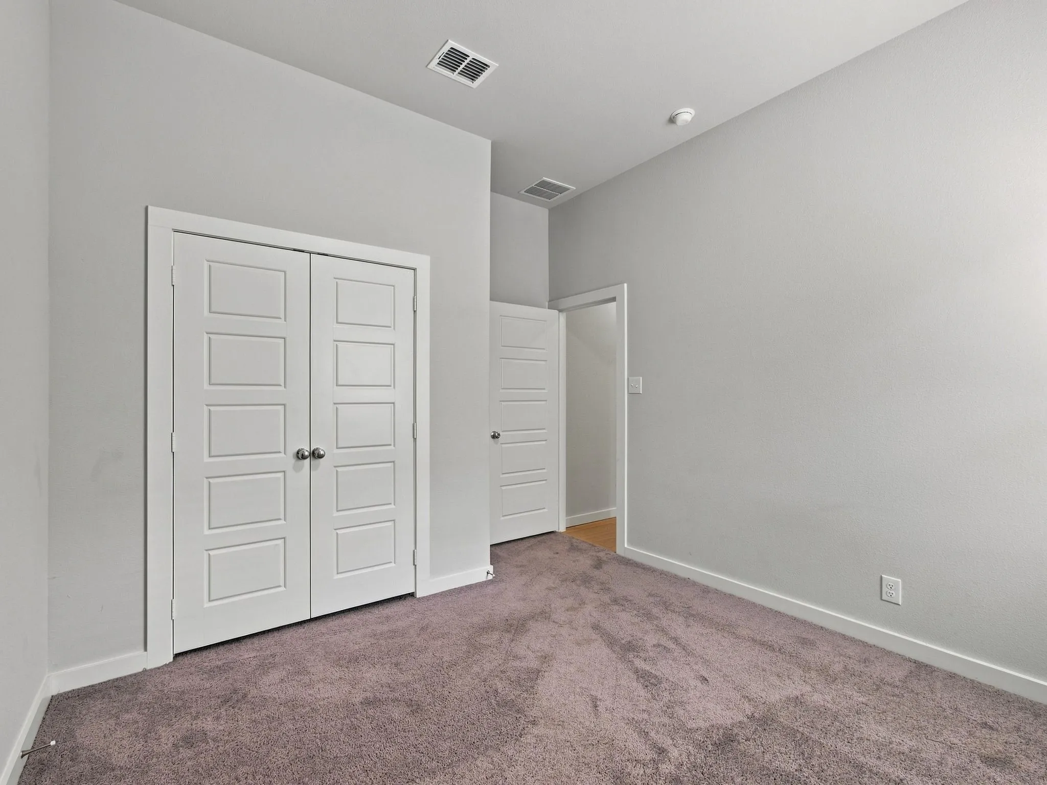 Neutral wall paint, carpeted flooring, white trim, recessed lighting, and panel doors