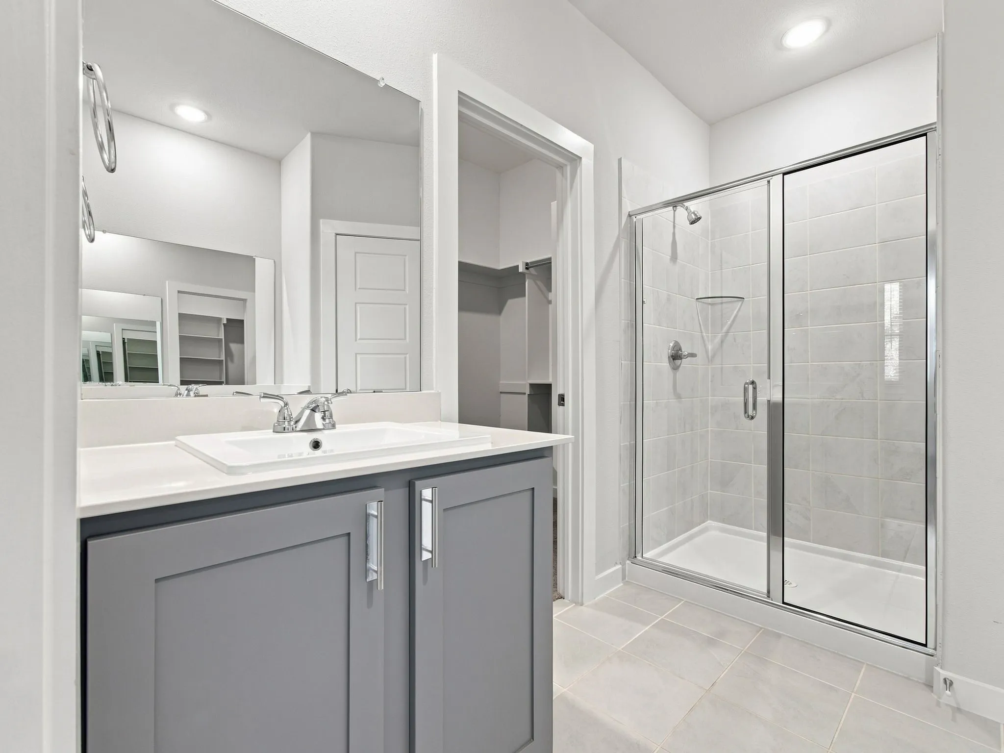 Bathroom featuring a single vanity with gray cabinetry, a white countertop, and a rectangular undermount sink