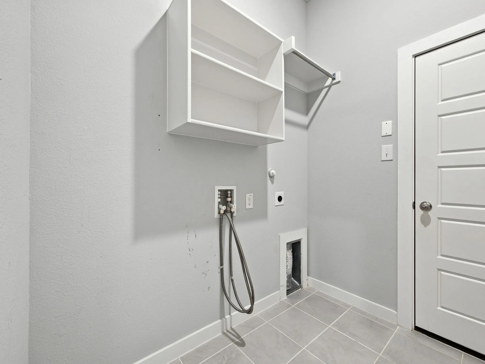 White built-in shelving, hanging rod, and light gray tiled flooring