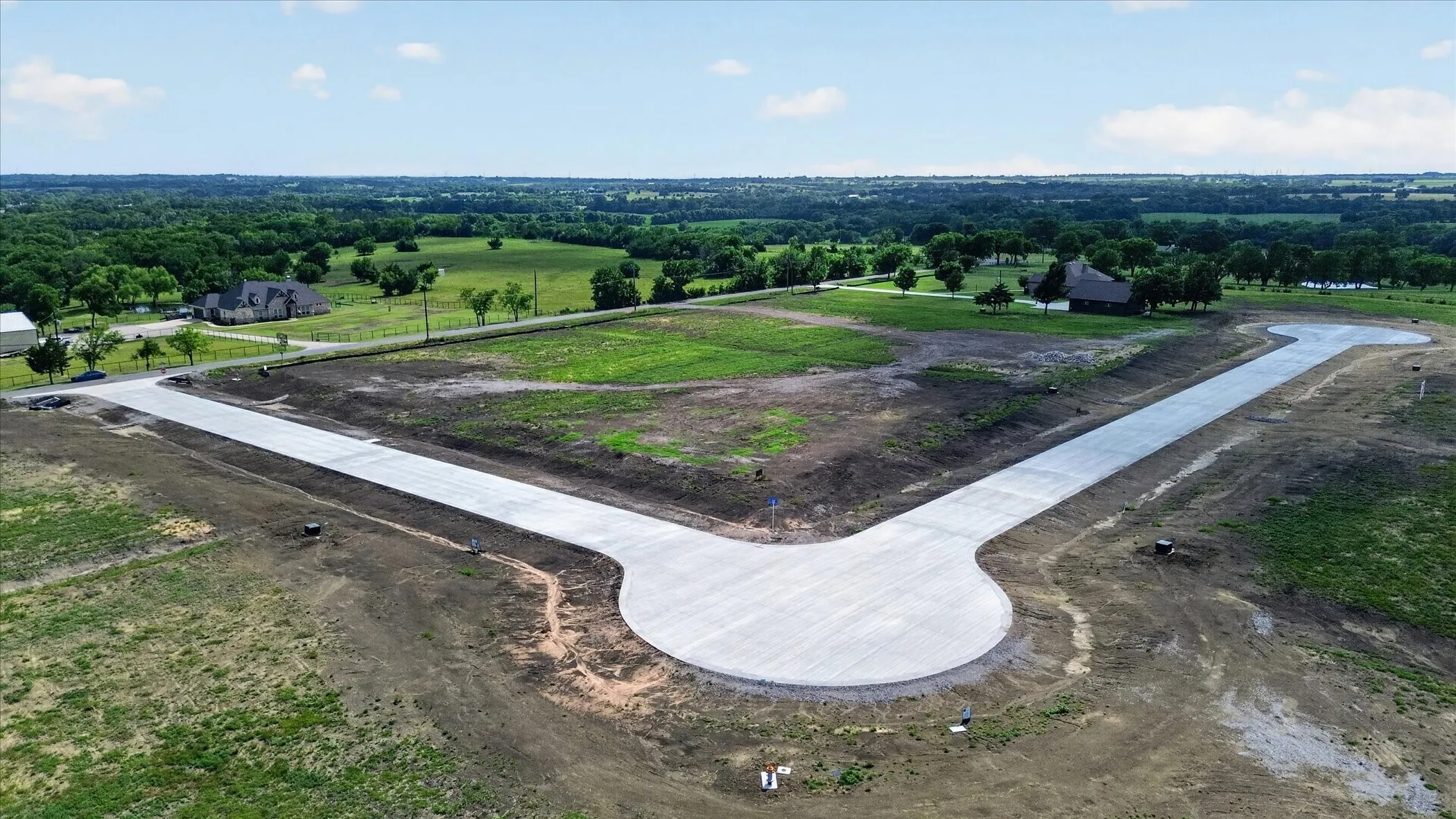 Newly paved cul-de-sac with surrounding undeveloped land