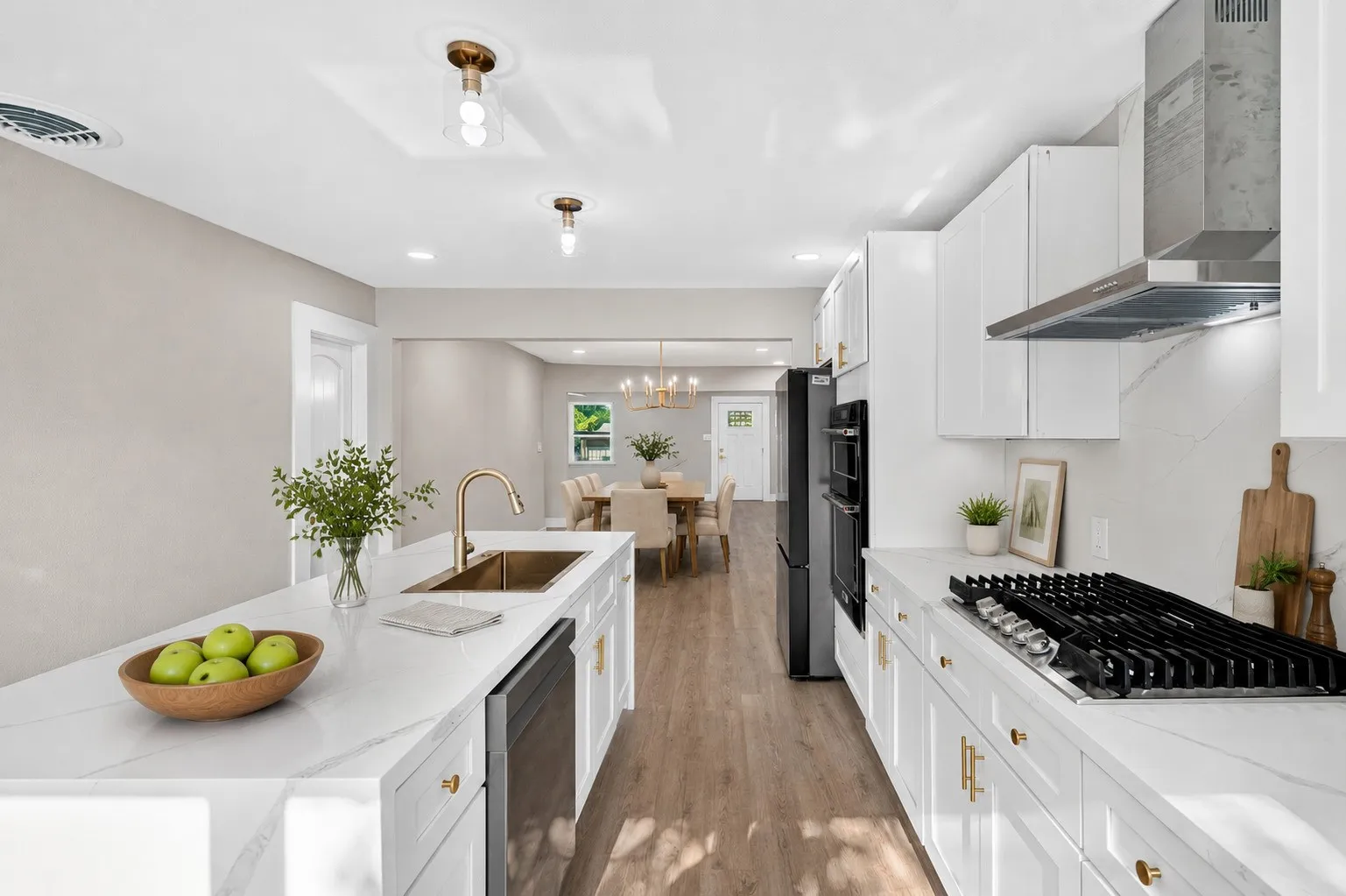 Kitchen featuring white cabinetry, stone countertops, stainless steel appliances, a gas range, and wood-finish flooring