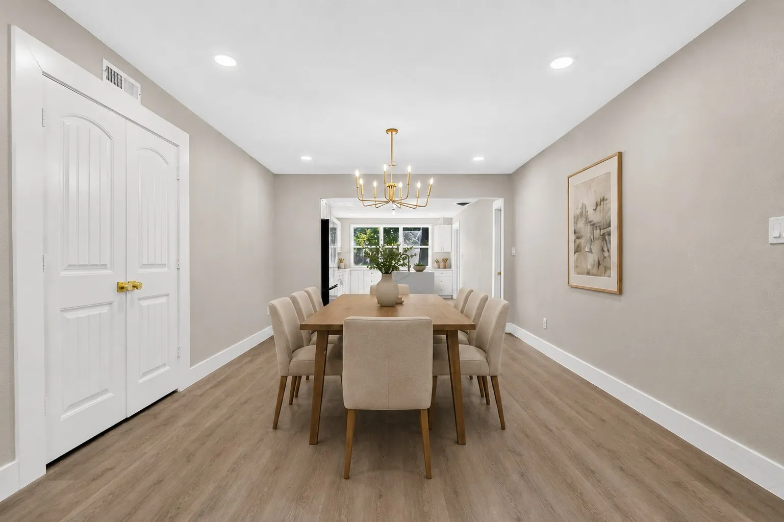Recessed lighting, wood-finish flooring, gold-toned chandelier, white trim, and paneled double doors