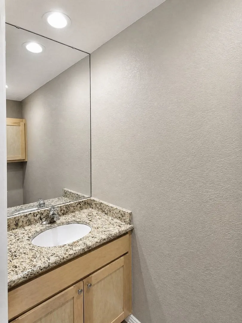 Recessed lighting above a full-height mirror