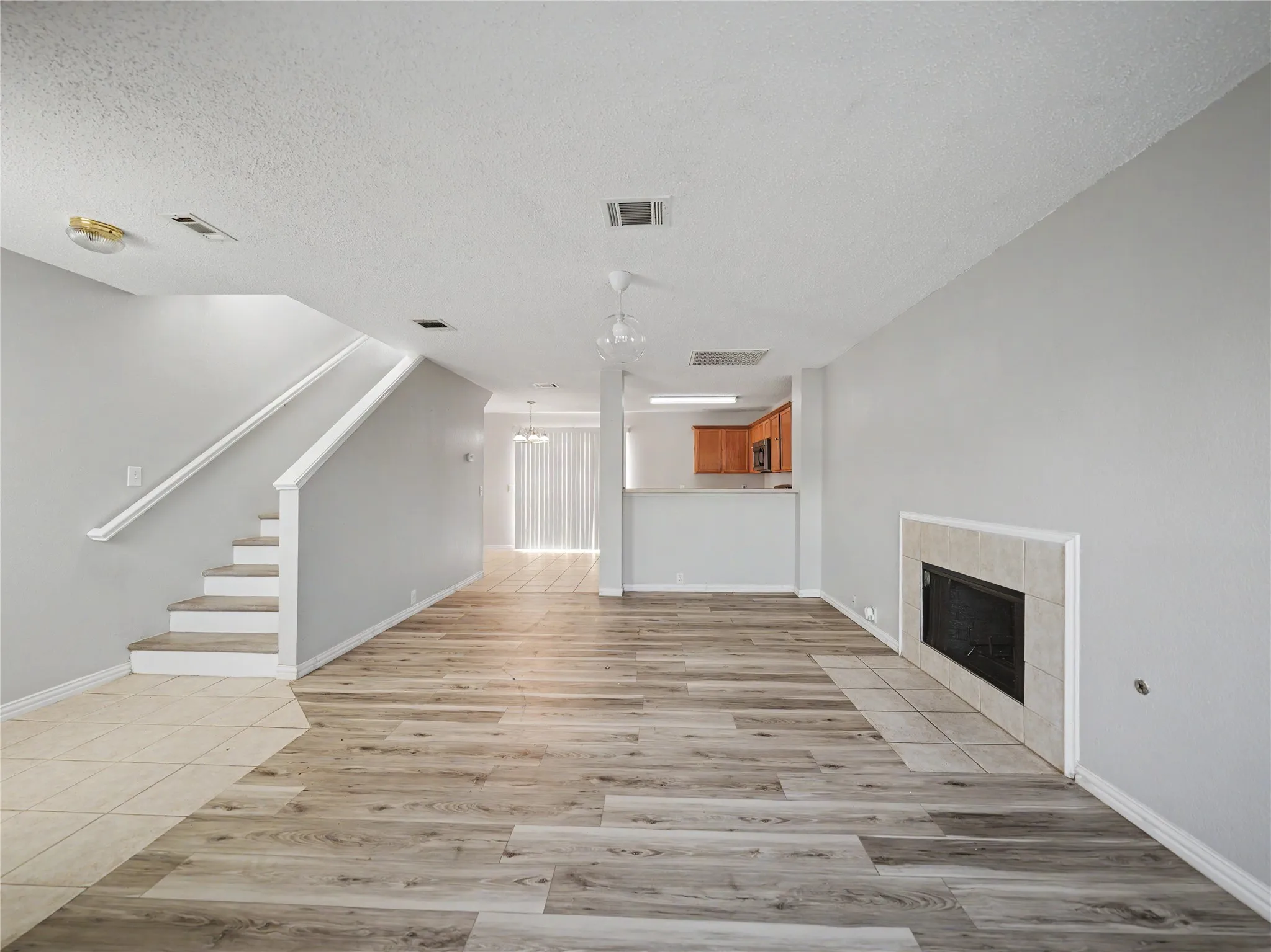 Wood-finish flooring throughout the main living area, complemented by a tile-surround fireplace