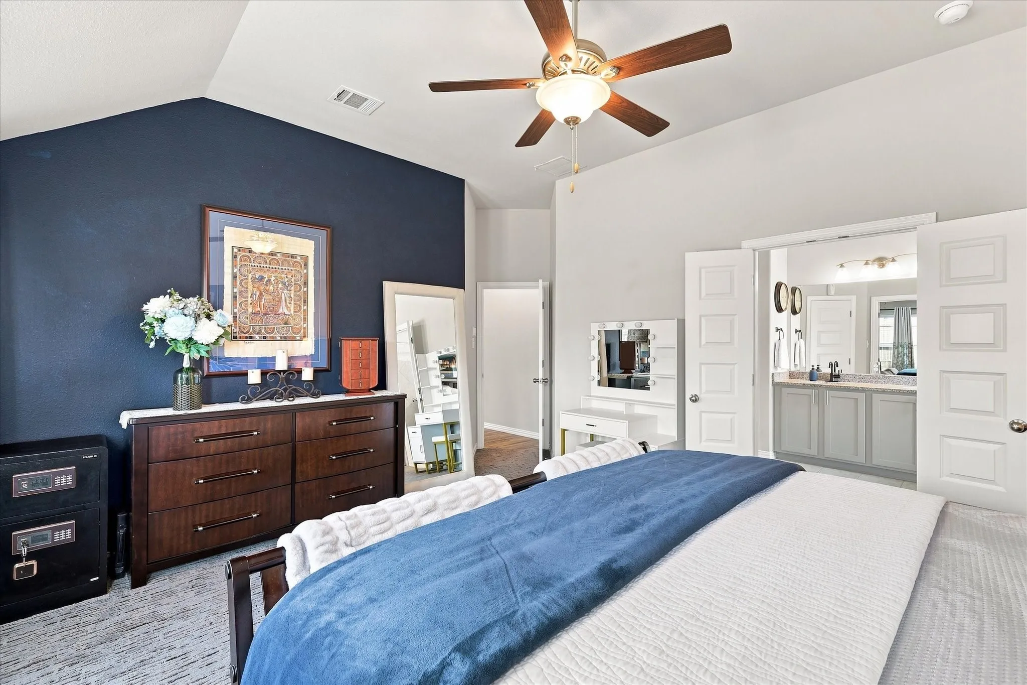 Spacious Primary Suite features a Soaring Vaulted Ceiling, Lighted Ceiling Fan, Plush Carpeting and Abundant Natural Light from multiple windows. Generous proportions provide Room for Additional Furnishings, while Direct Ensuite Bath Access creates a Comfortable Owner’s Retreat.