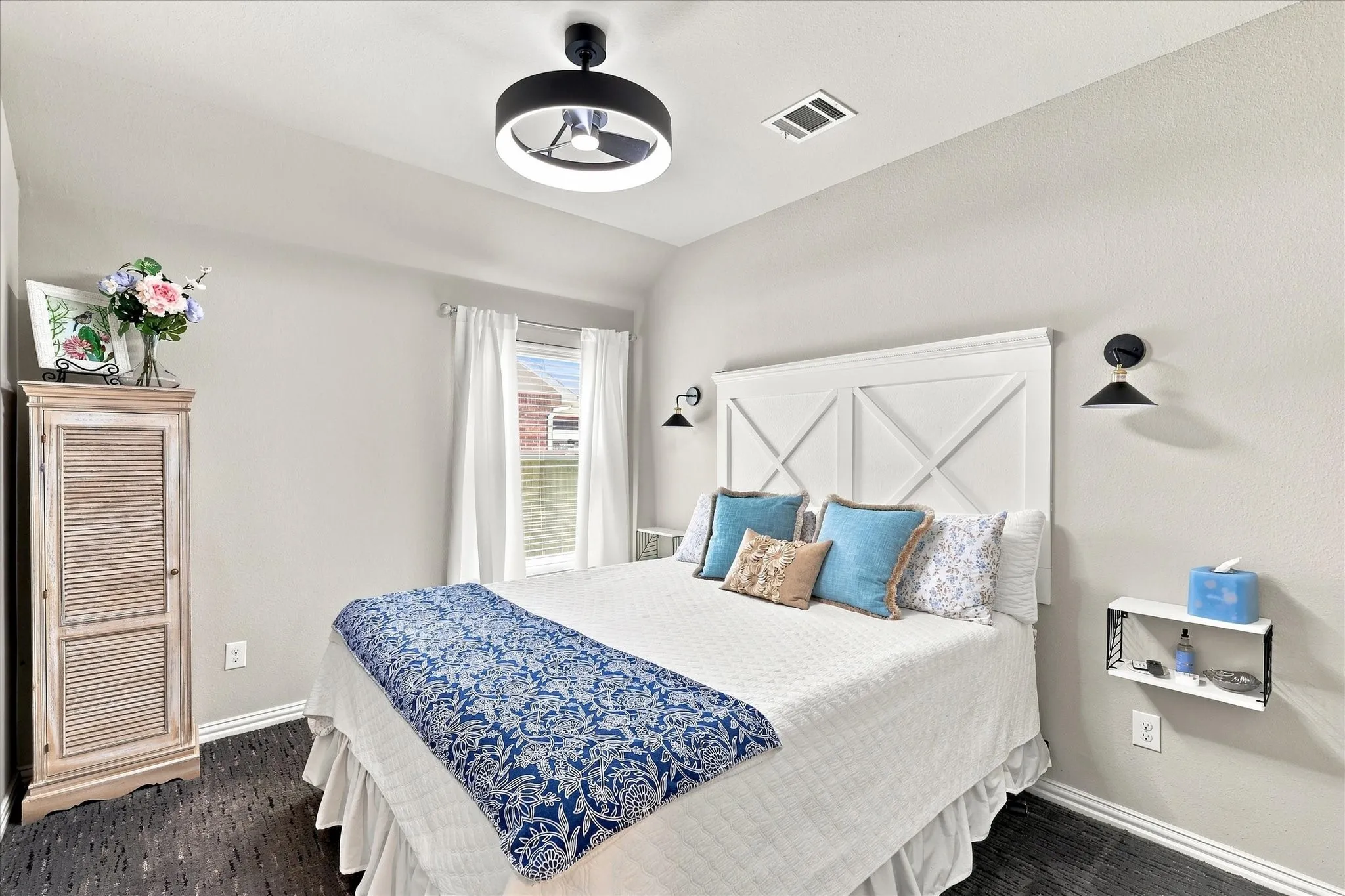 Inviting Secondary Bedroom features High Ceilings, Plush Carpeting, Abundant Natural Light, A modern Ceiling Fan with Lighting, Contemporary Wall Sconces , and a Private Closet complete the space.