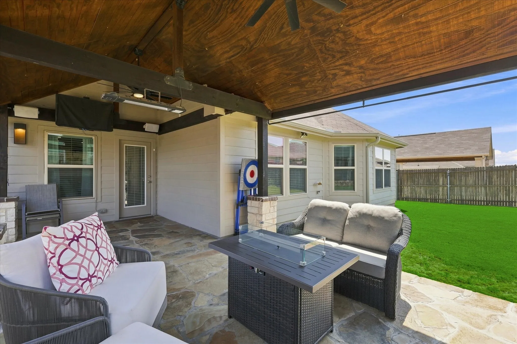 Impressive Outdoor Living Area features an Expansive Covered Flagstone Patio, Wood-plank Vaulted Ceiling, Exposed Beams, Lighted Ceiling Fan, Outdoor Heater. A Dramatic Floor-to-Ceiling Stone Wood Burning Fireplace Anchors the Space, while the Extended Patio and Large Fenced Backyard provide Plenty of Room for Dining, Grilling and Entertaining.