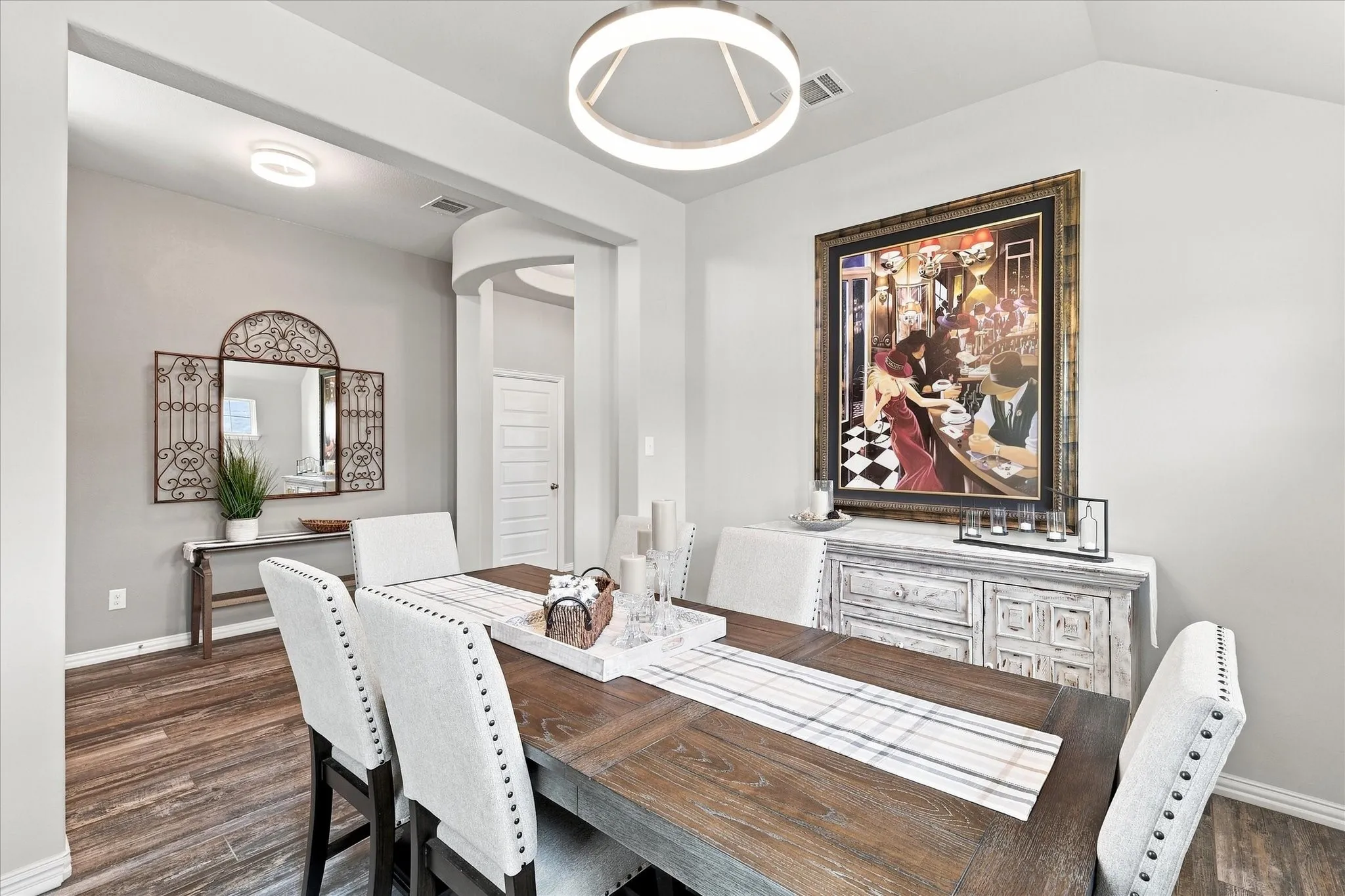 Formal Dining Room features a Vaulted Ceiling, Contemporary Designer Lighting, Upgraded Wood-look Tile Flooring and Abundant Natural Light. The Open Design and Architectural Details create an Impressive Space for Entertaining.
