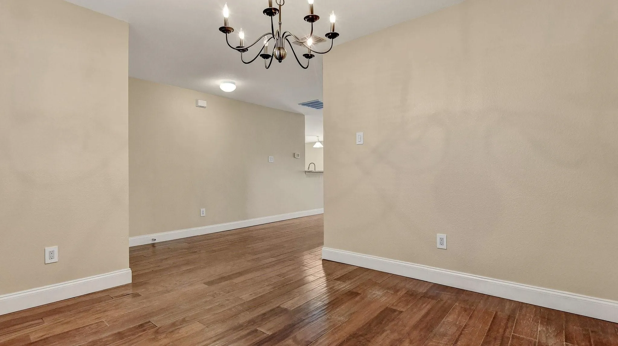 Wood-finish flooring with white baseboards, complemented by neutral wall tones