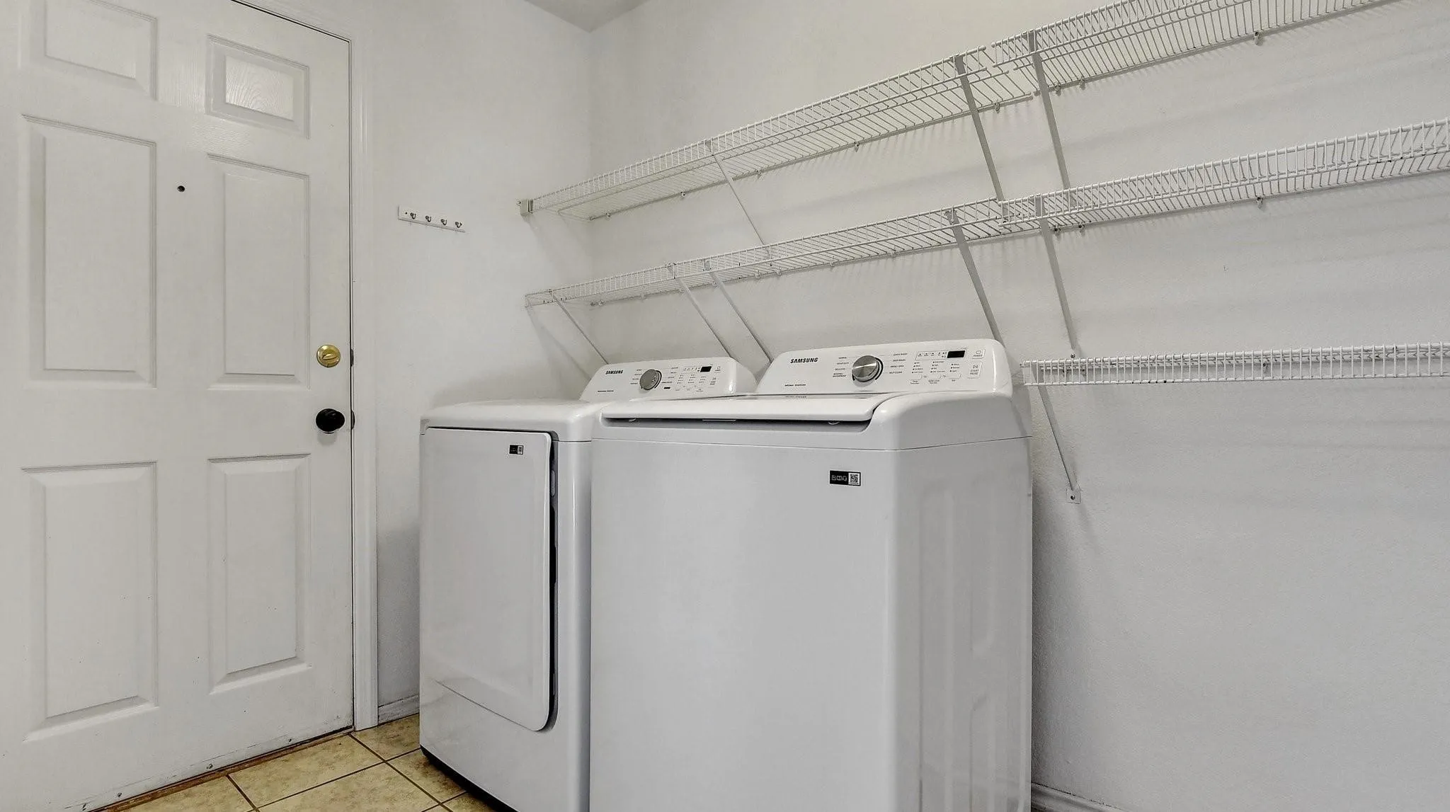 Utility area with tile flooring and extensive wire shelving