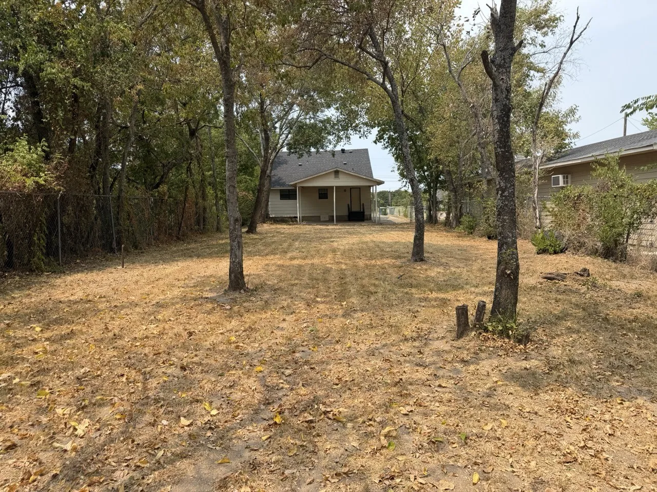 Expansive yard with mature trees and a rear covered porch