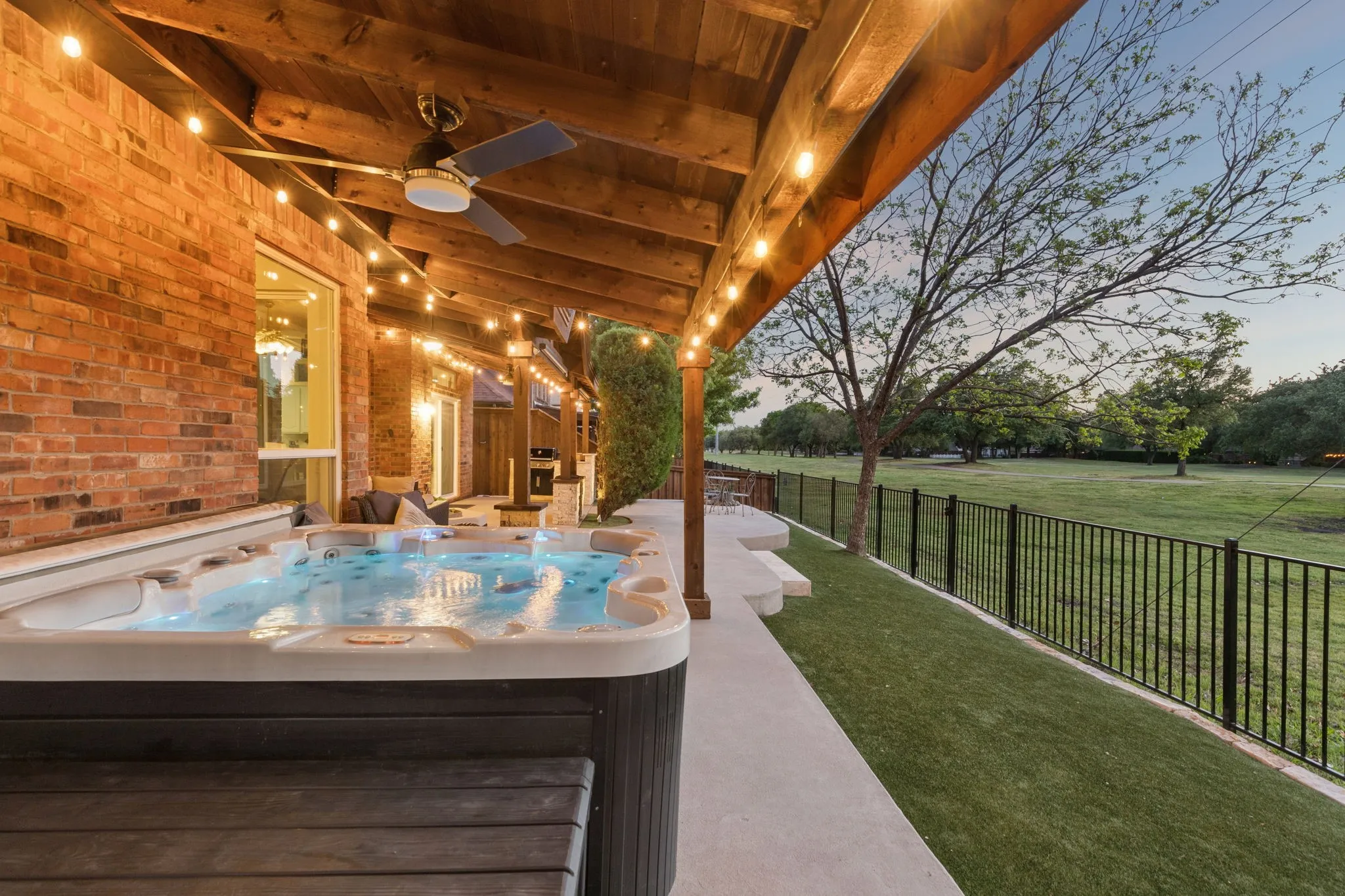 Outdoor living with extended concrete and arbor coverage, ceiling fans and decorative lights