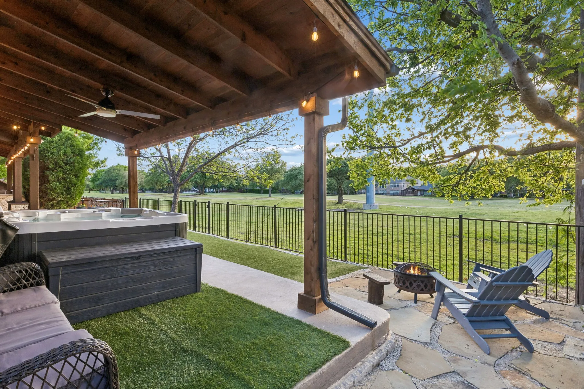 Outdoor living with extended concrete and arbor coverage, ceiling fans and decorative lights