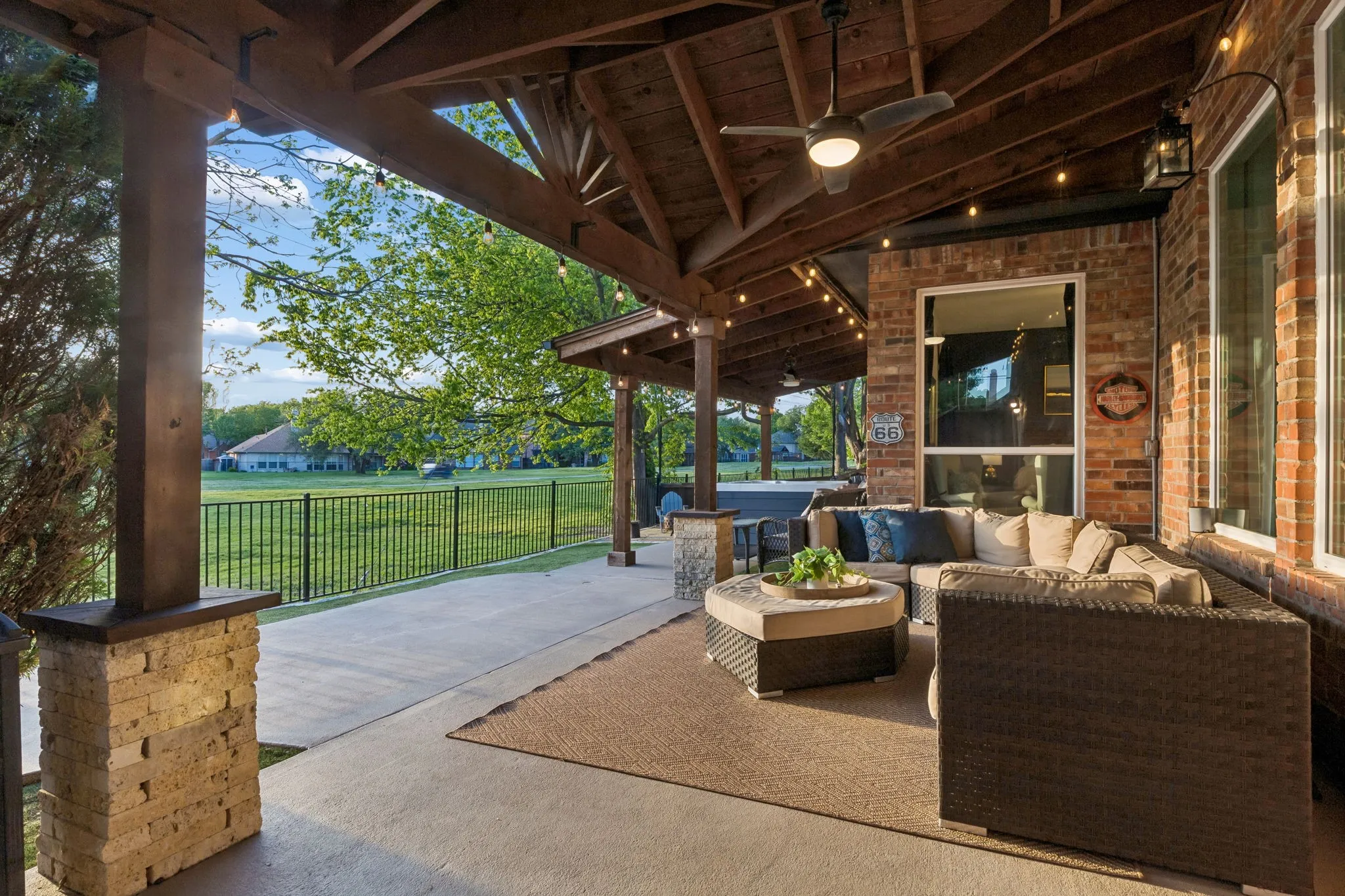 Outdoor living with extended concrete and arbor coverage, ceiling fans and decorative lights