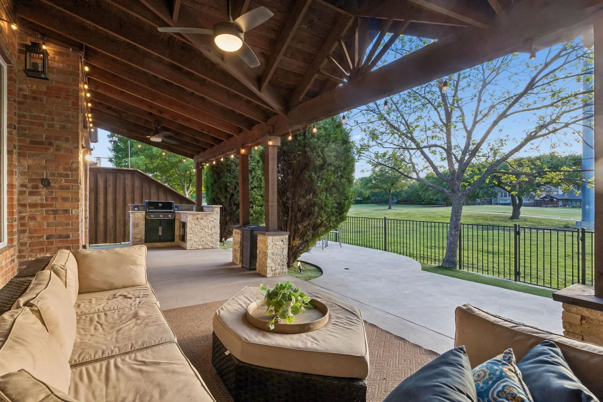 Outdoor living with extended concrete and arbor coverage, ceiling fans and decorative lights