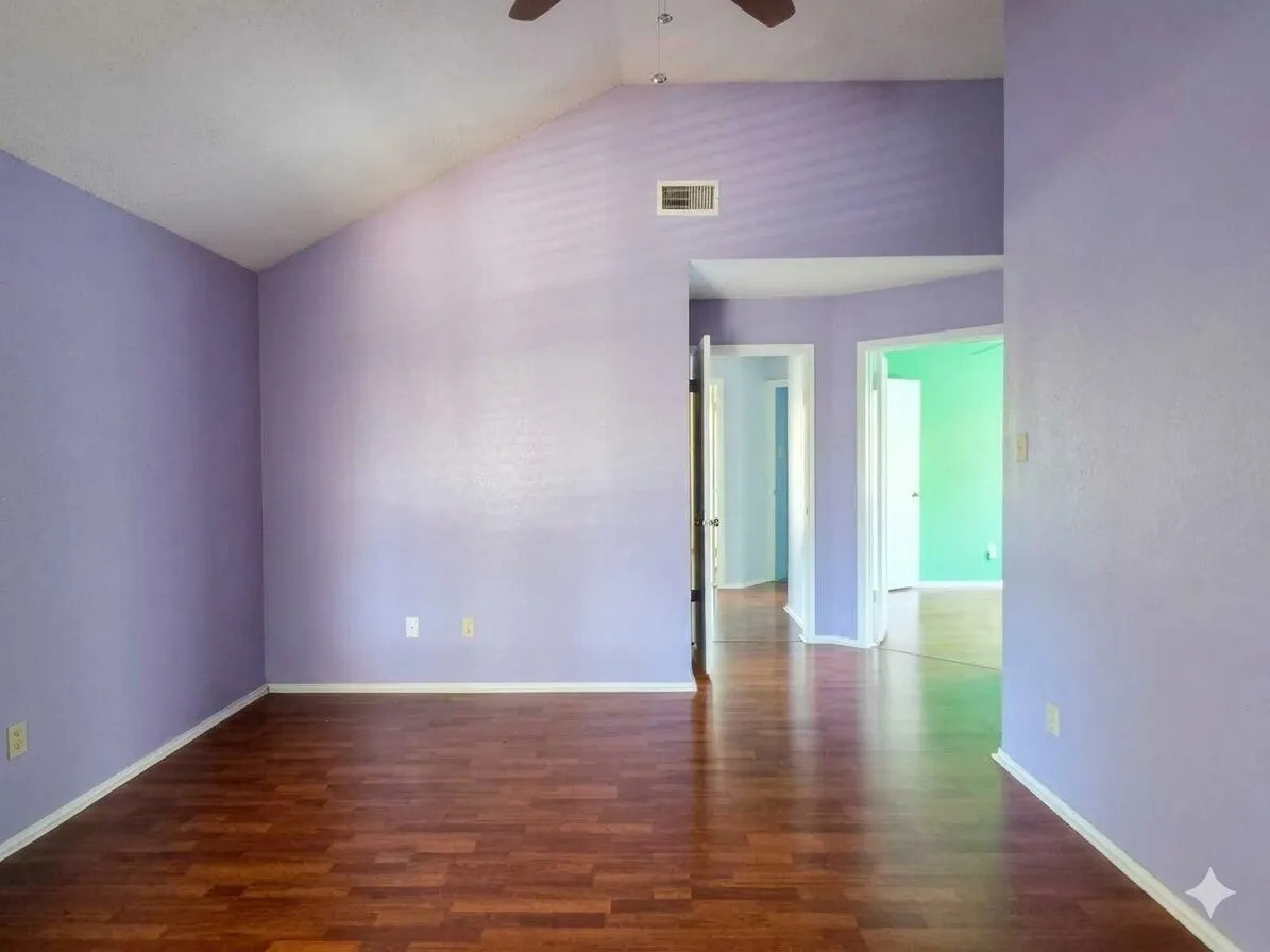 Wood-finish flooring with a vaulted ceiling and recessed lighting