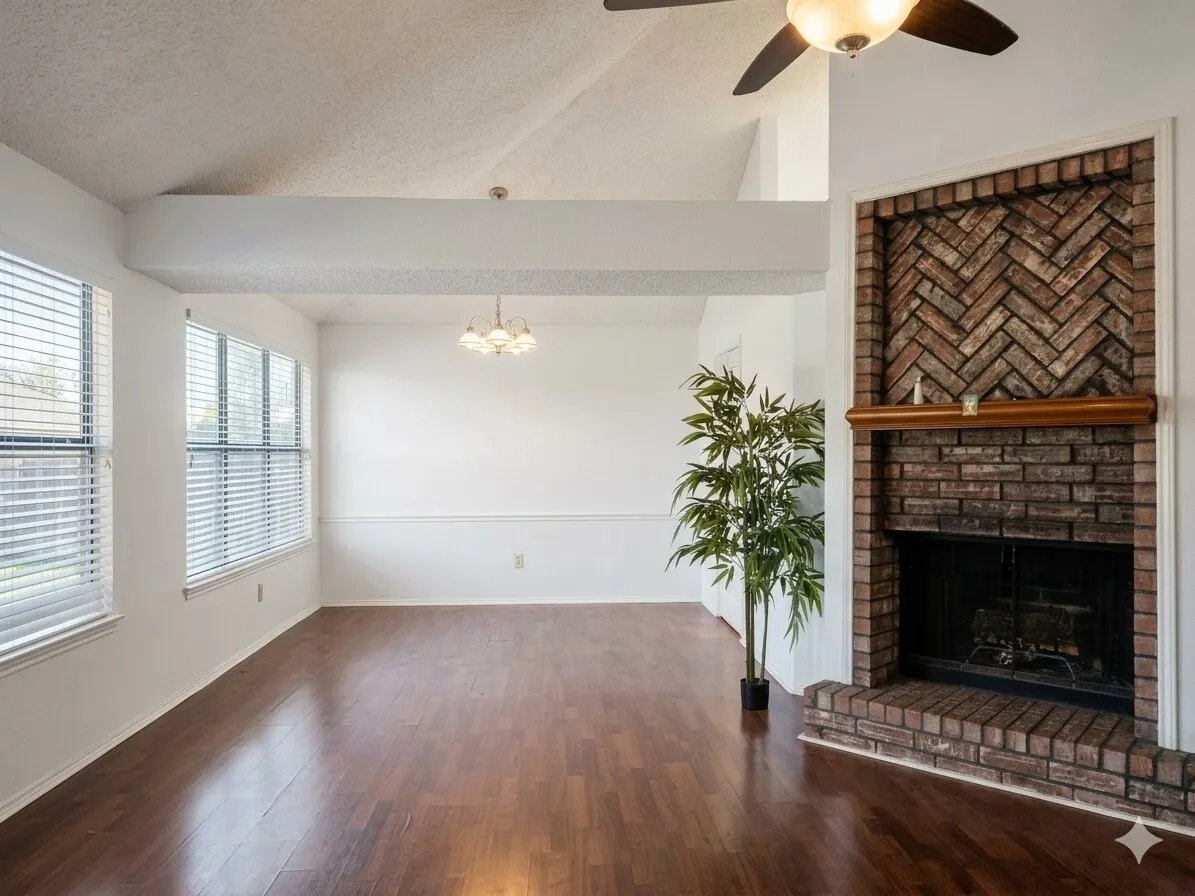 Vaulted ceiling, wood-finish flooring, brick fireplace with herringbone detail, ceiling fan with integrated lighting, and multiple windows