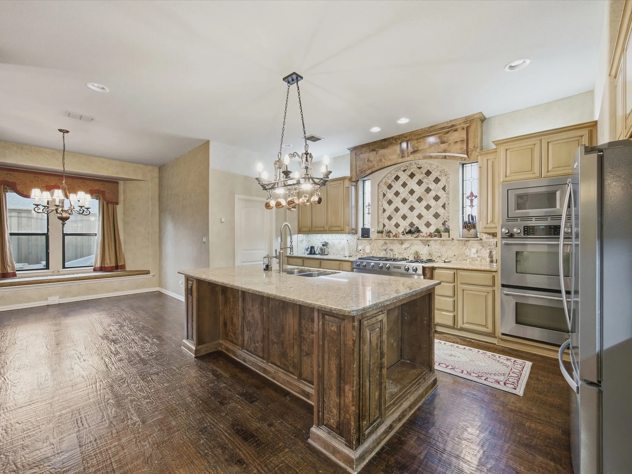 Gourmet kitchen featuring a wood-finish island with a stone countertop, stainless steel appliances, and wood-finish cabinetry