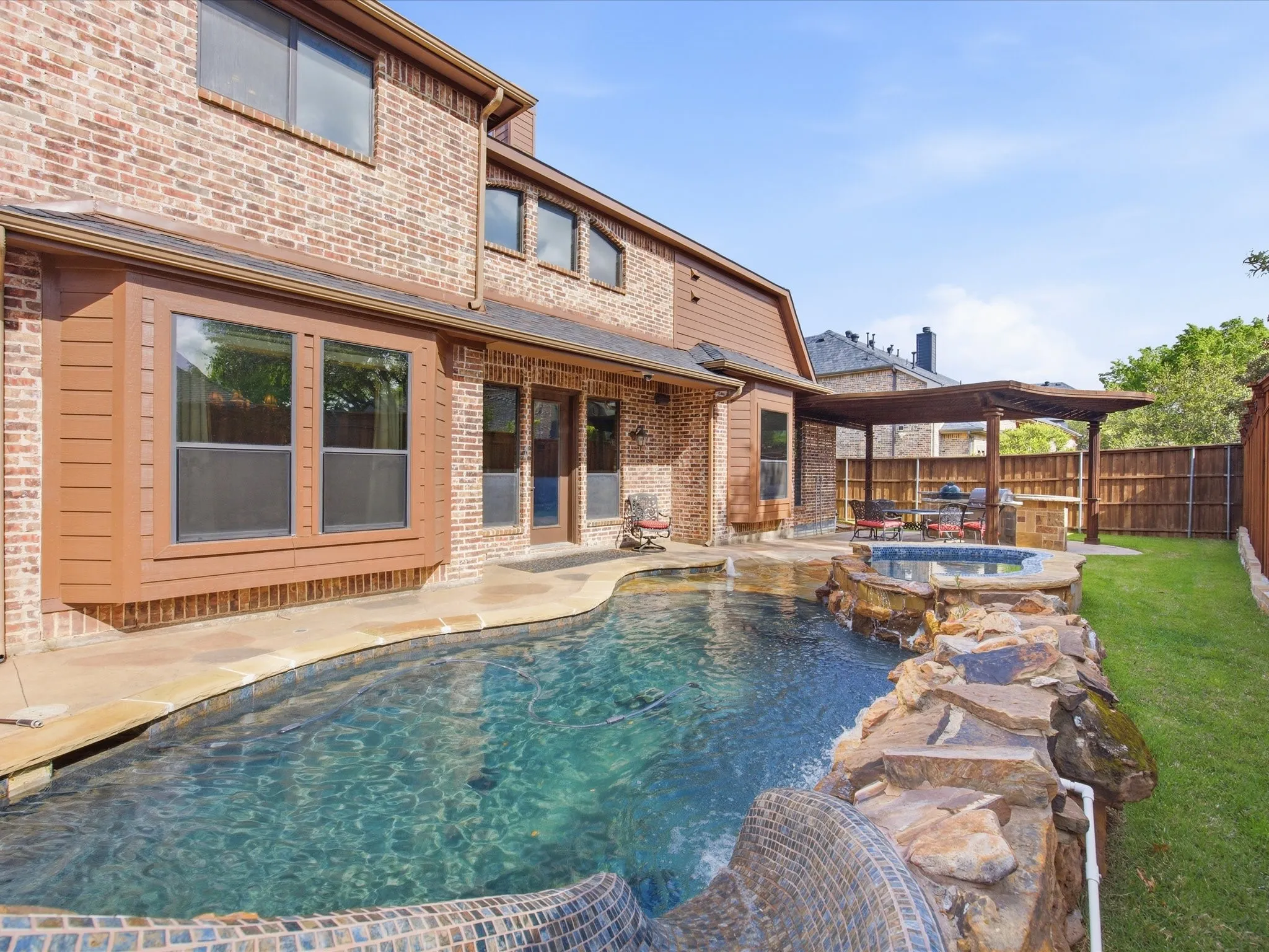 Brick exterior featuring multiple windows and French doors