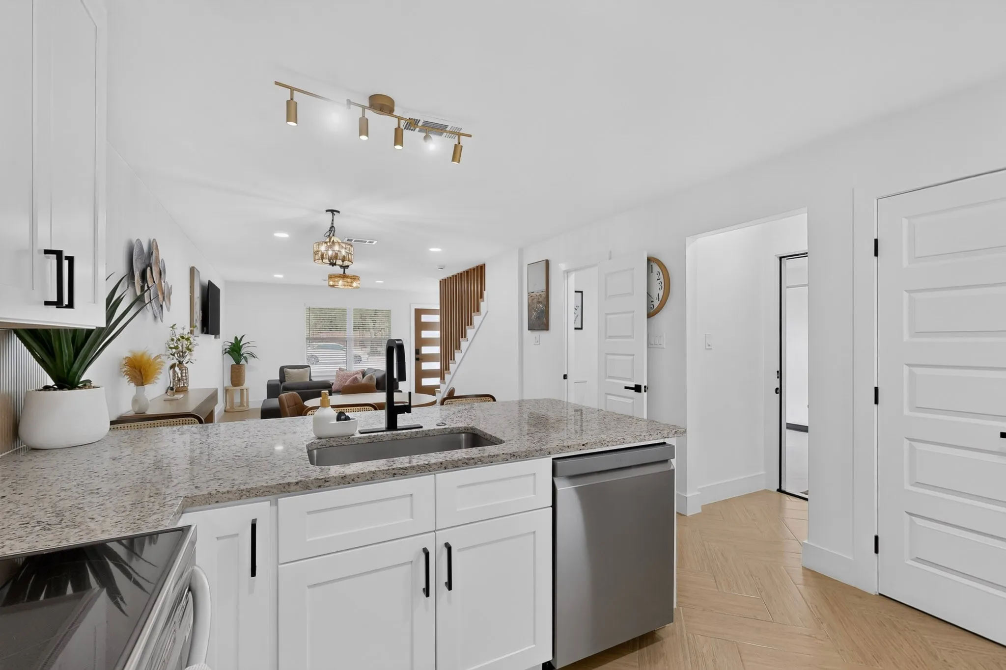 Kitchen island with a granite countertop, undermount stainless steel sink, and matte black faucet
