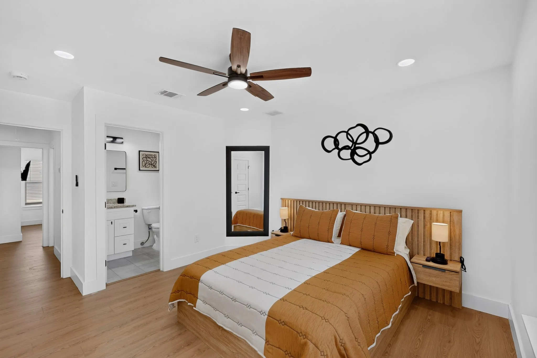 Recessed lighting, wood-finish flooring, ceiling fan, attached vanity with a stone countertop, and a full-length mirror
