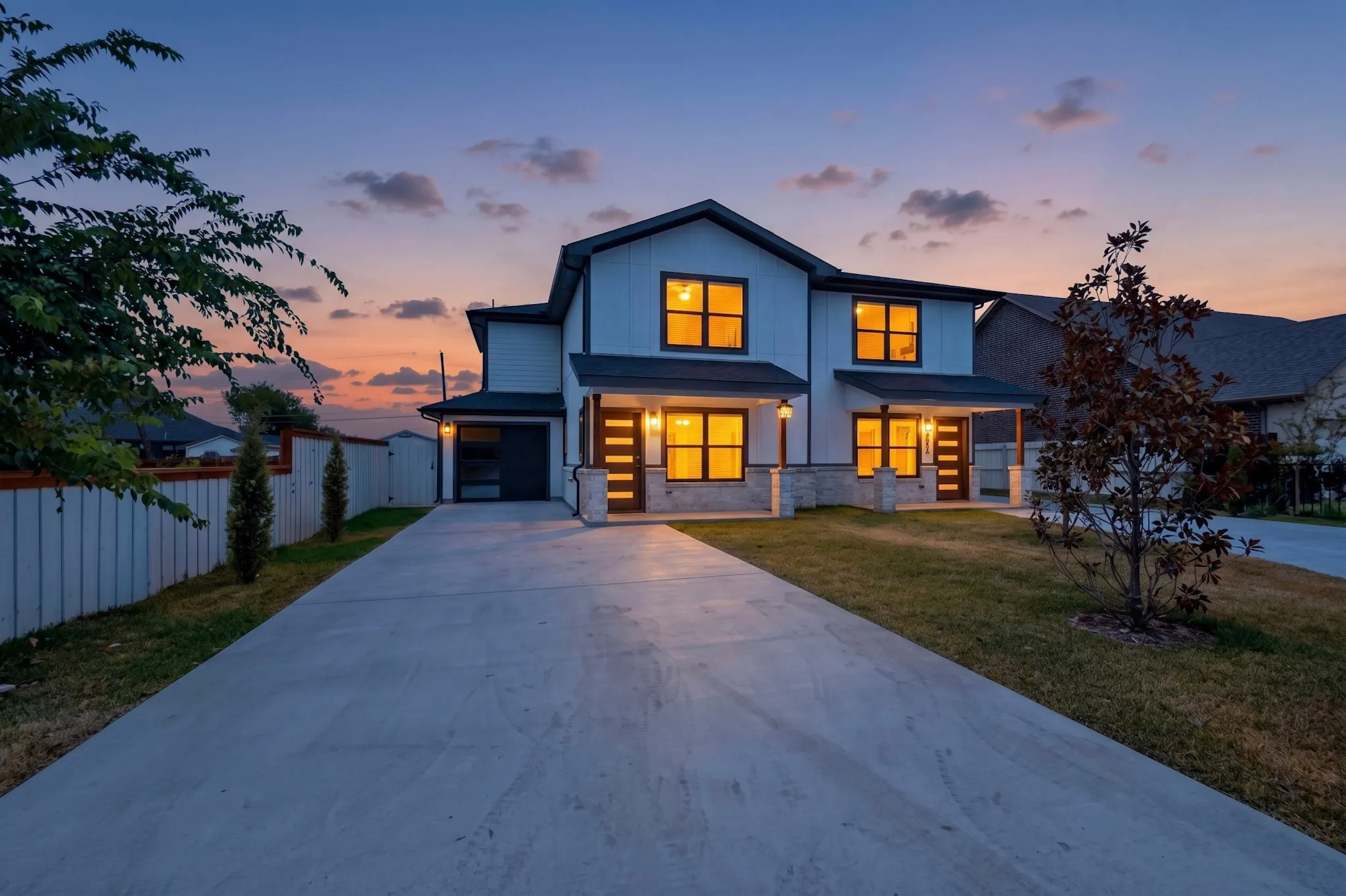 Modern exterior with board and batten siding, stone facade, and dark framed windows