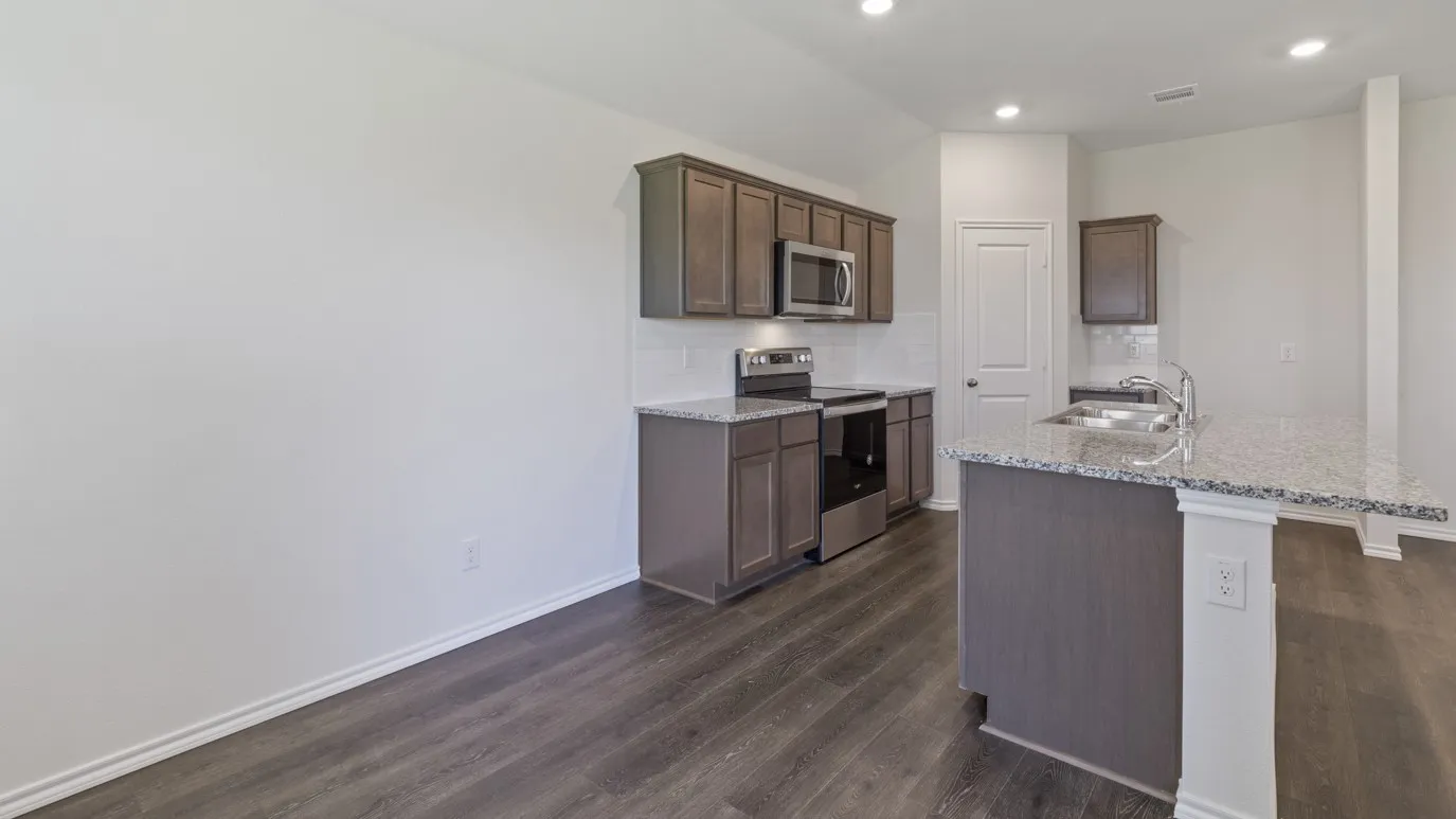 Kitchen featuring wood-finish flooring, recessed lighting, and a kitchen island with a double sink