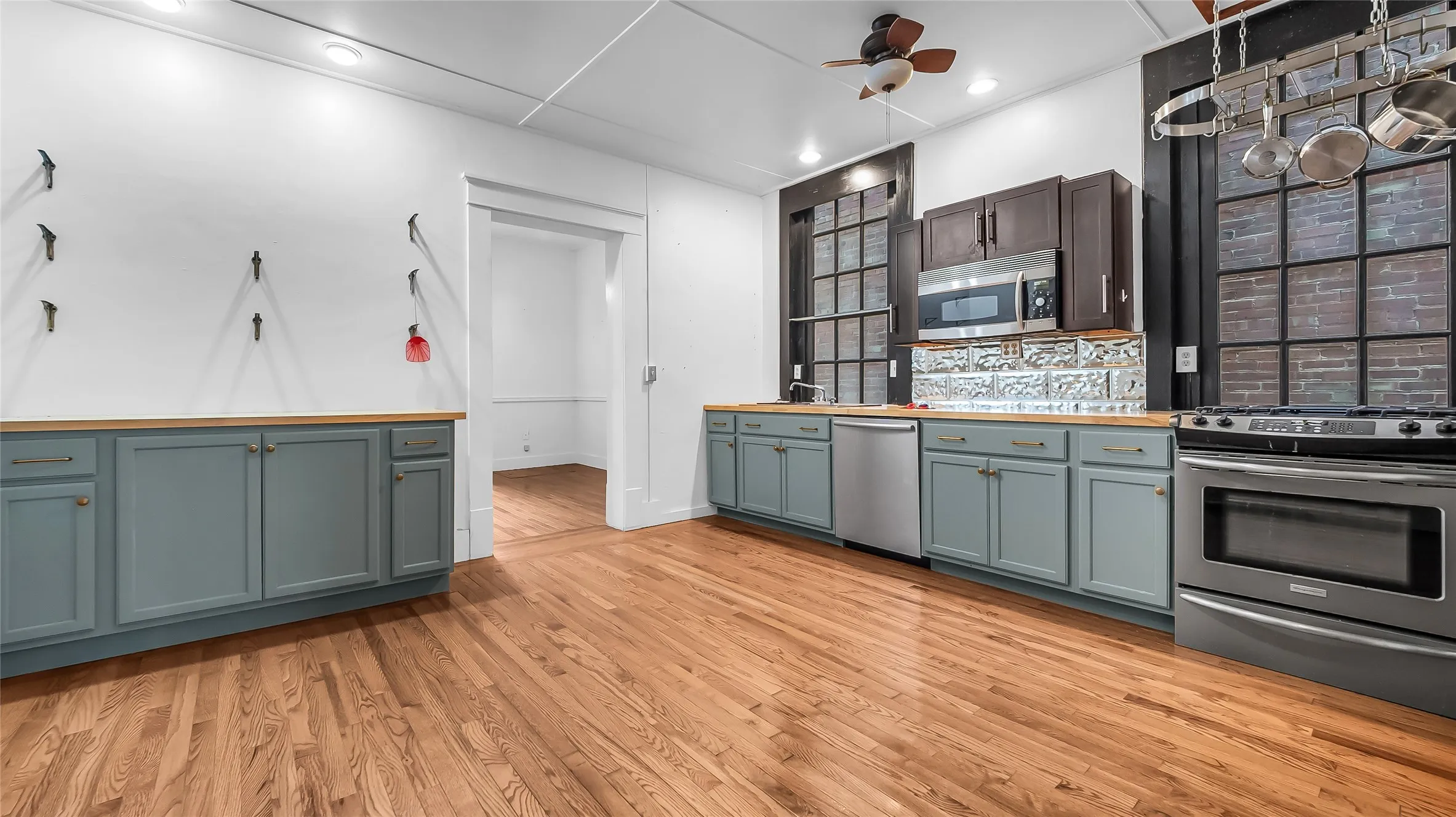 Wood-finish flooring throughout, with light blue cabinetry and wood-finish countertops